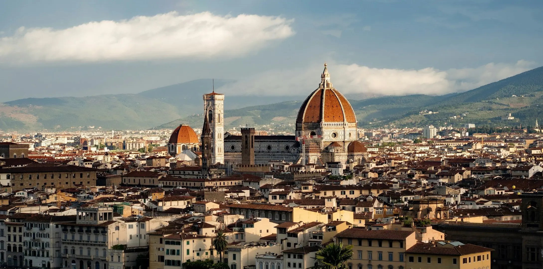 Utsikt över Florens stad med den ikoniska katedralen Santa Maria del Fiore mot bakgrund av de toskanska bergen.