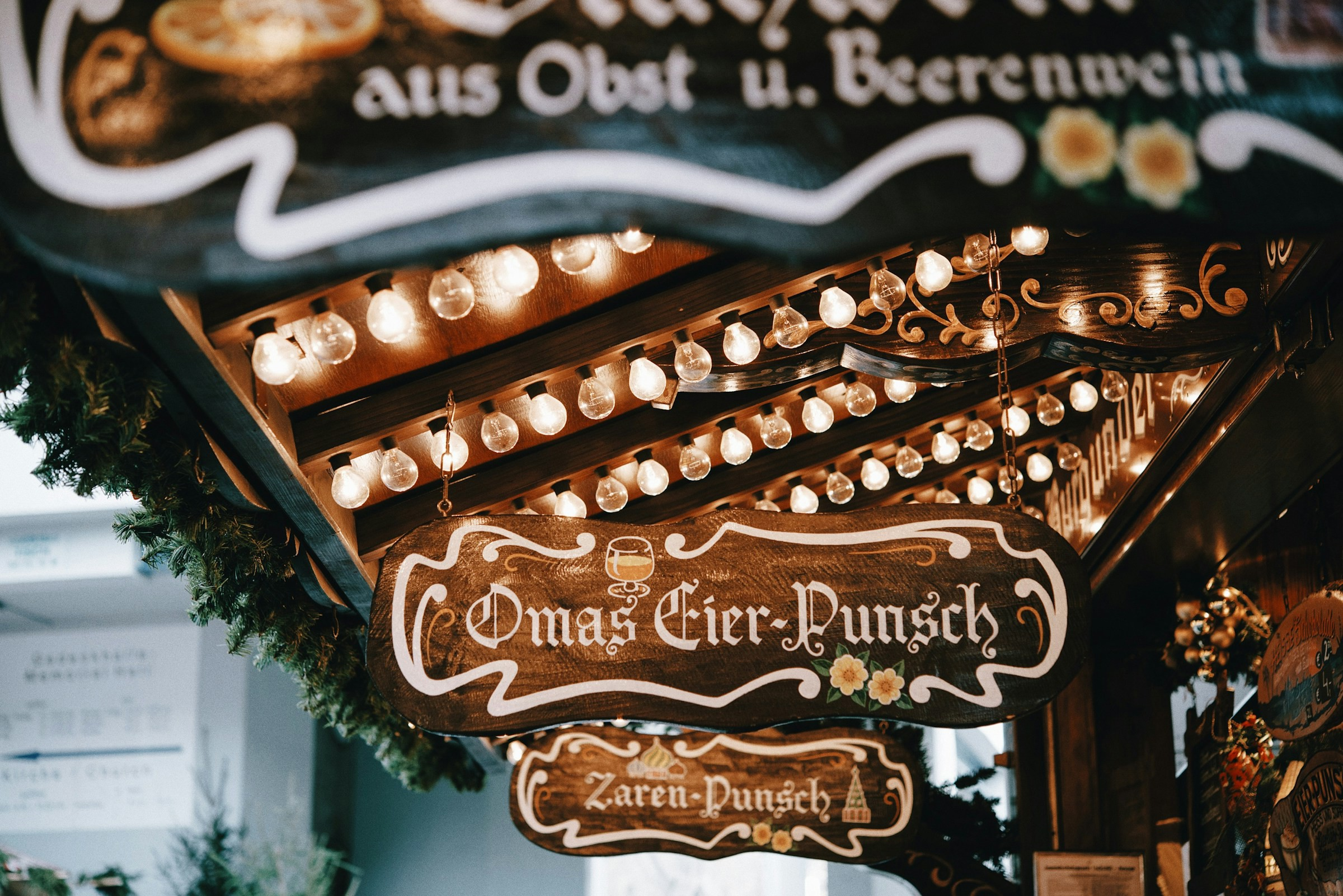 ulpunschstånd i Lubeck, Tyskland med traditionell stiliserad skyltning och festlig belysning, julmarknad."
