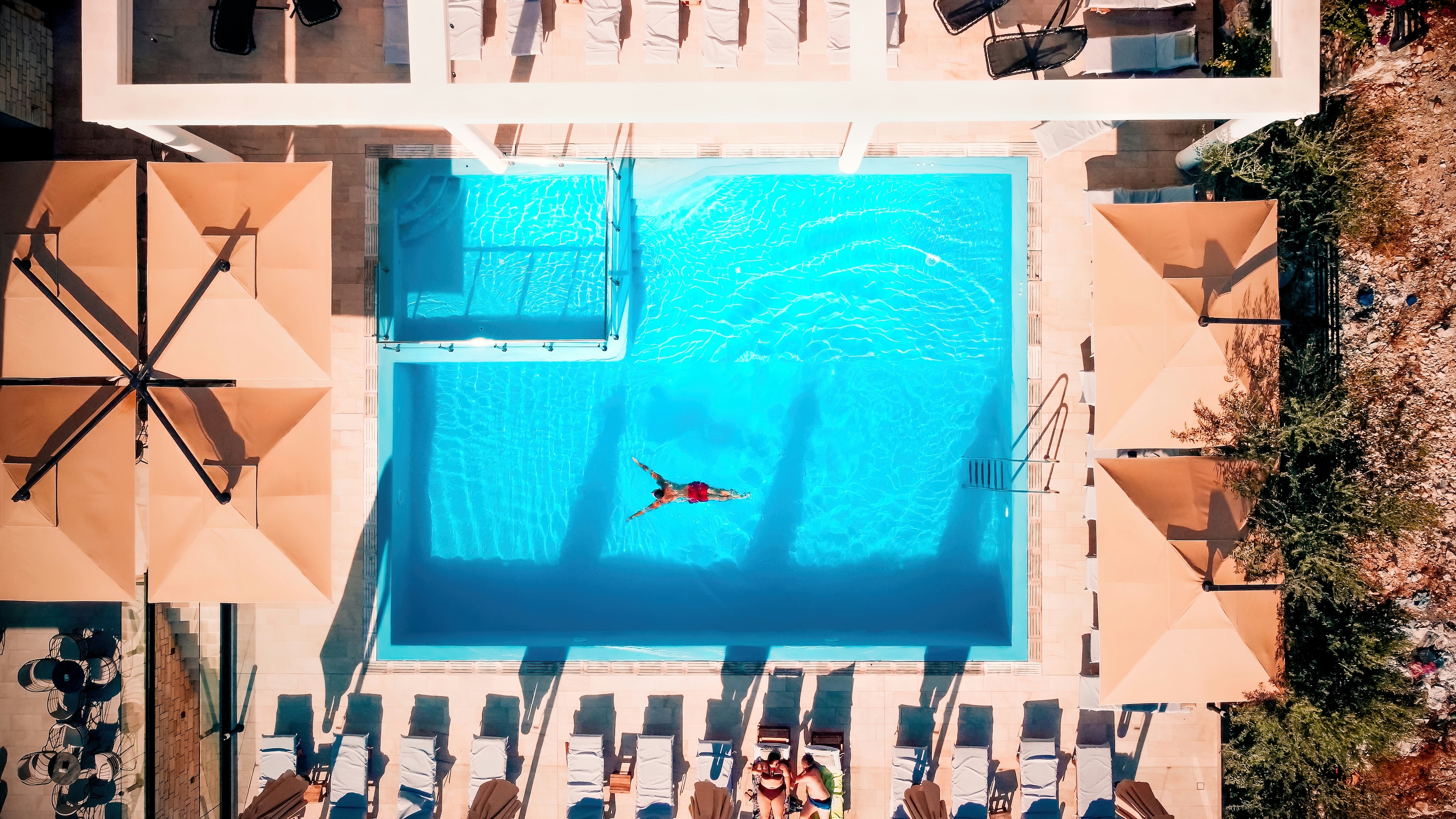vy ovanifrån på ett hotell med pool och en man som simmar i Saranda-Ksamil