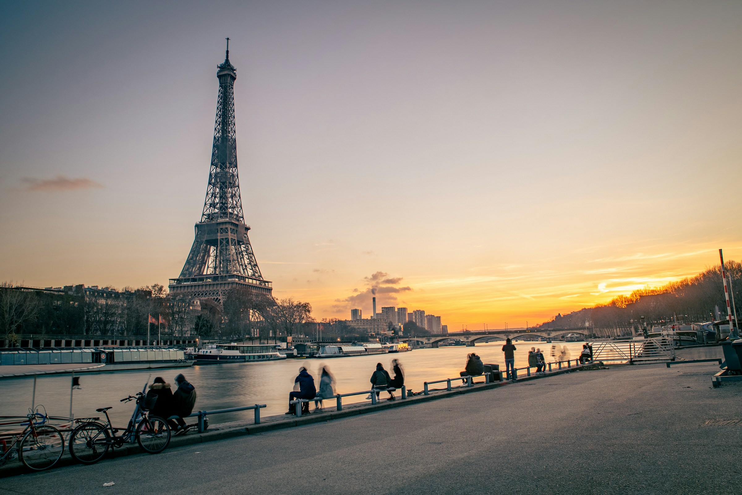 Solnedgång vid en flod framför Eiffel Tornet i Paris en höstkväll