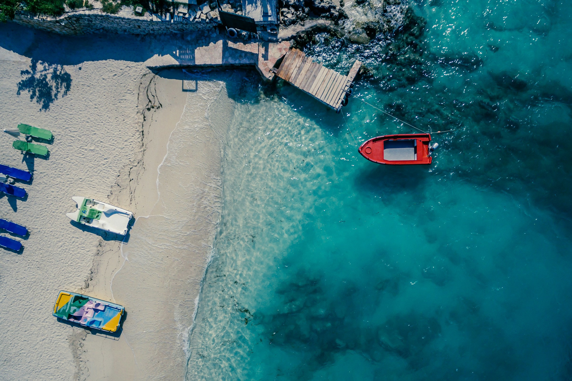 vy ovanifrån på strand med små båtar i blått hav i Saranda-Ksamil