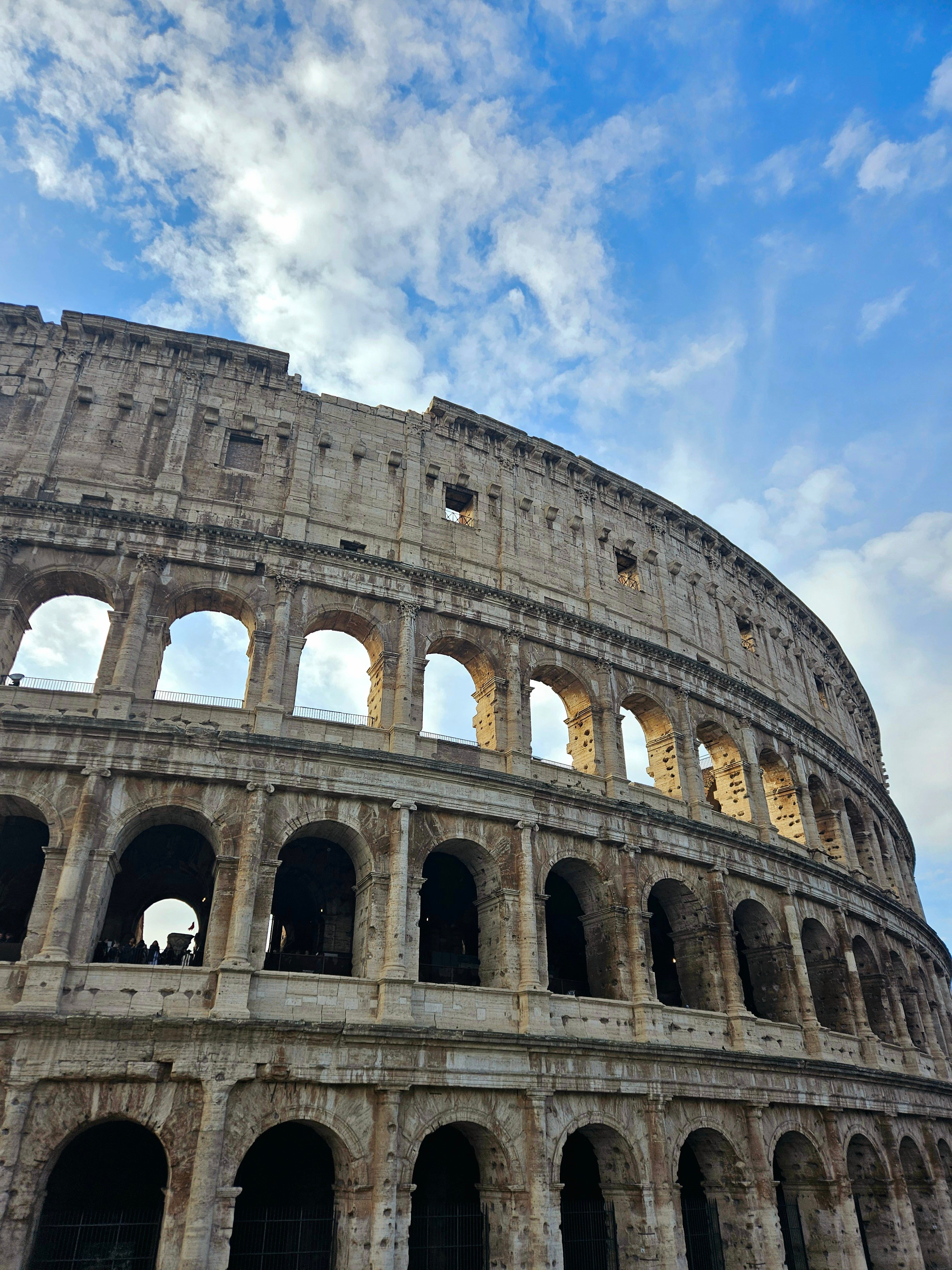 Närbild på Colosseum upp mot en blå himmel i Rom