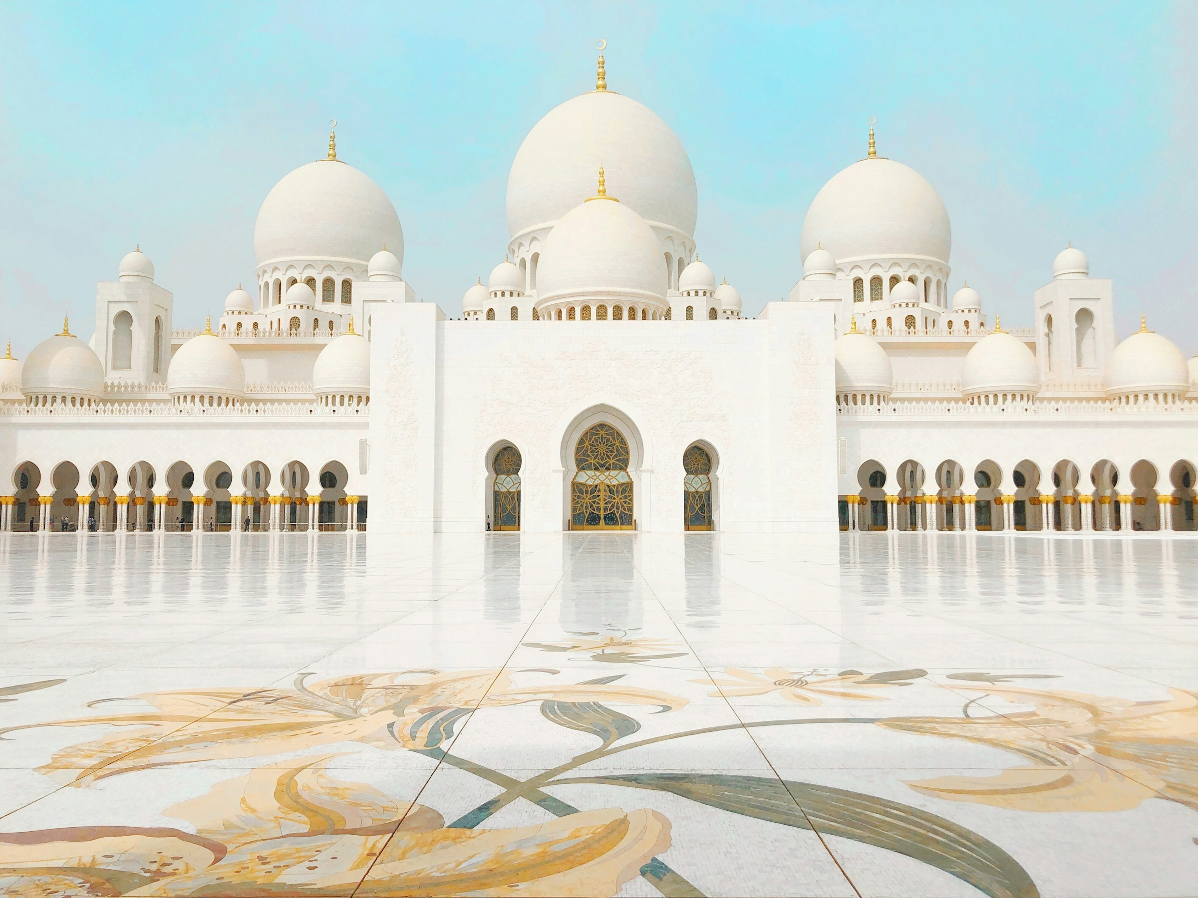Shejk Zayed-moskén i Abu Dhabi med vita kupoler och reflekterande ytor.