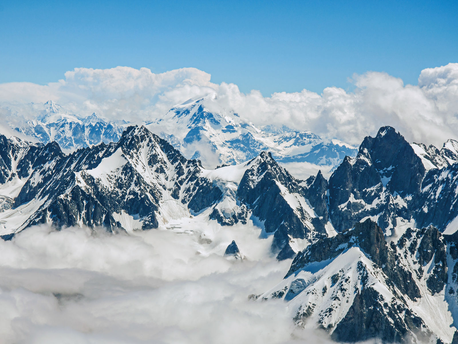 Resa till Alperna - höga snötäckta berg i Alperna med blå himmel i bakgrunden i Alperna
