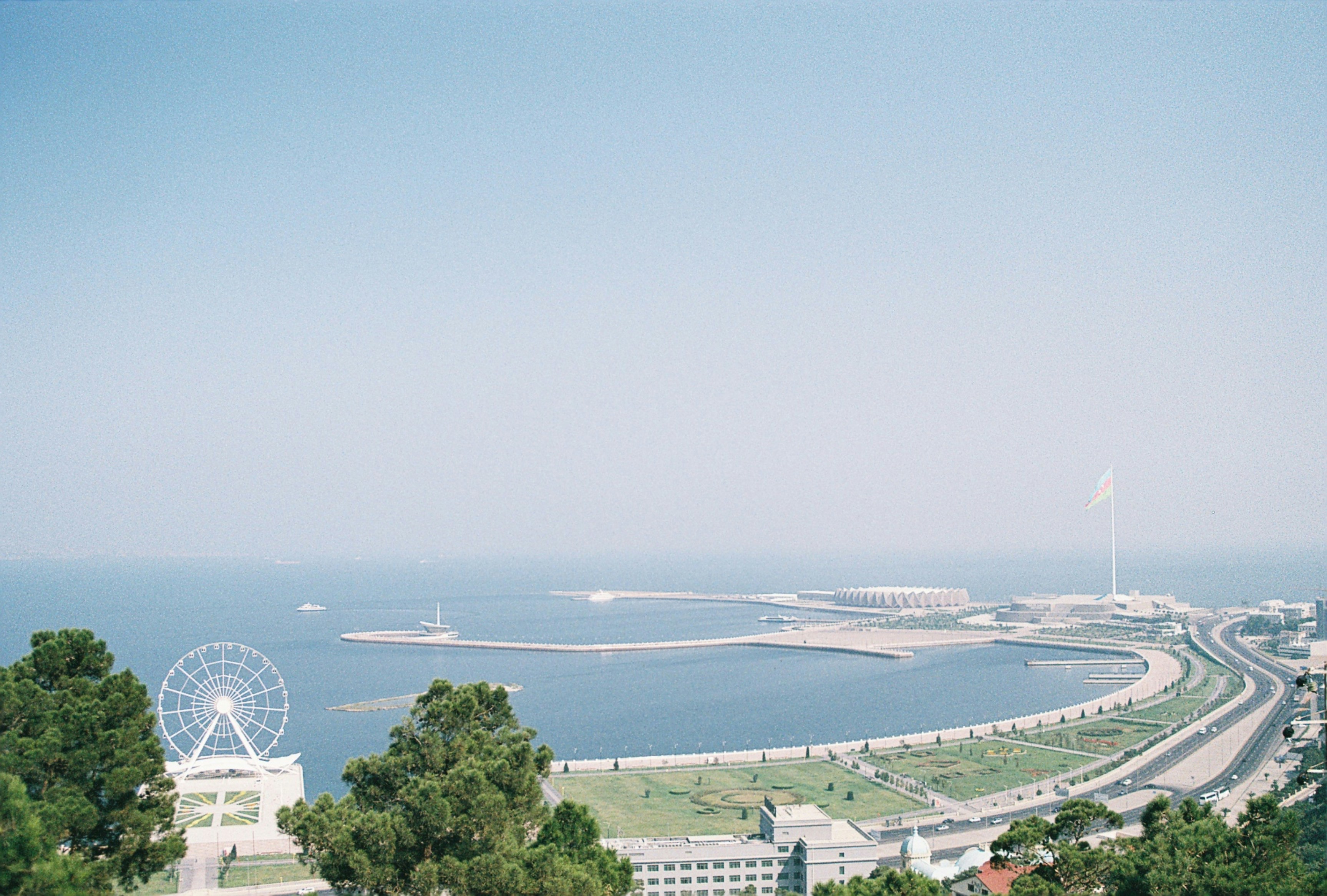 Coastal port with beach in Baku meets blue sea and misty blue sky in the background