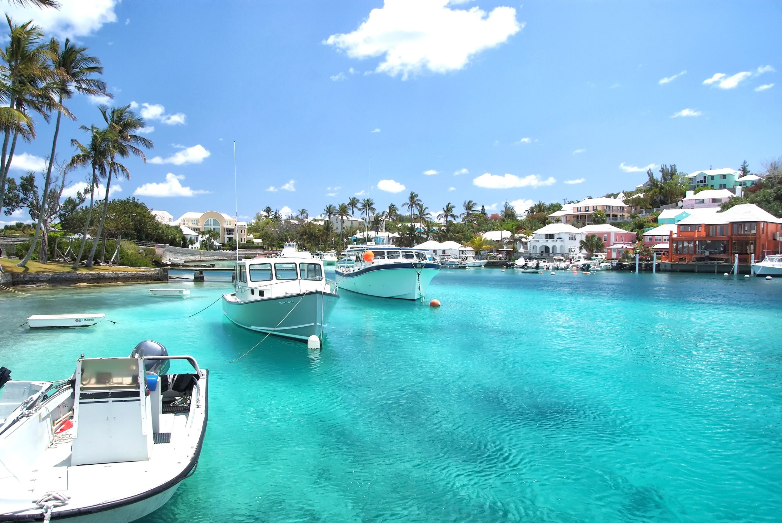 Panoramic view of turquoise blue waters in a small harbor with boats and buildings in Bermuda