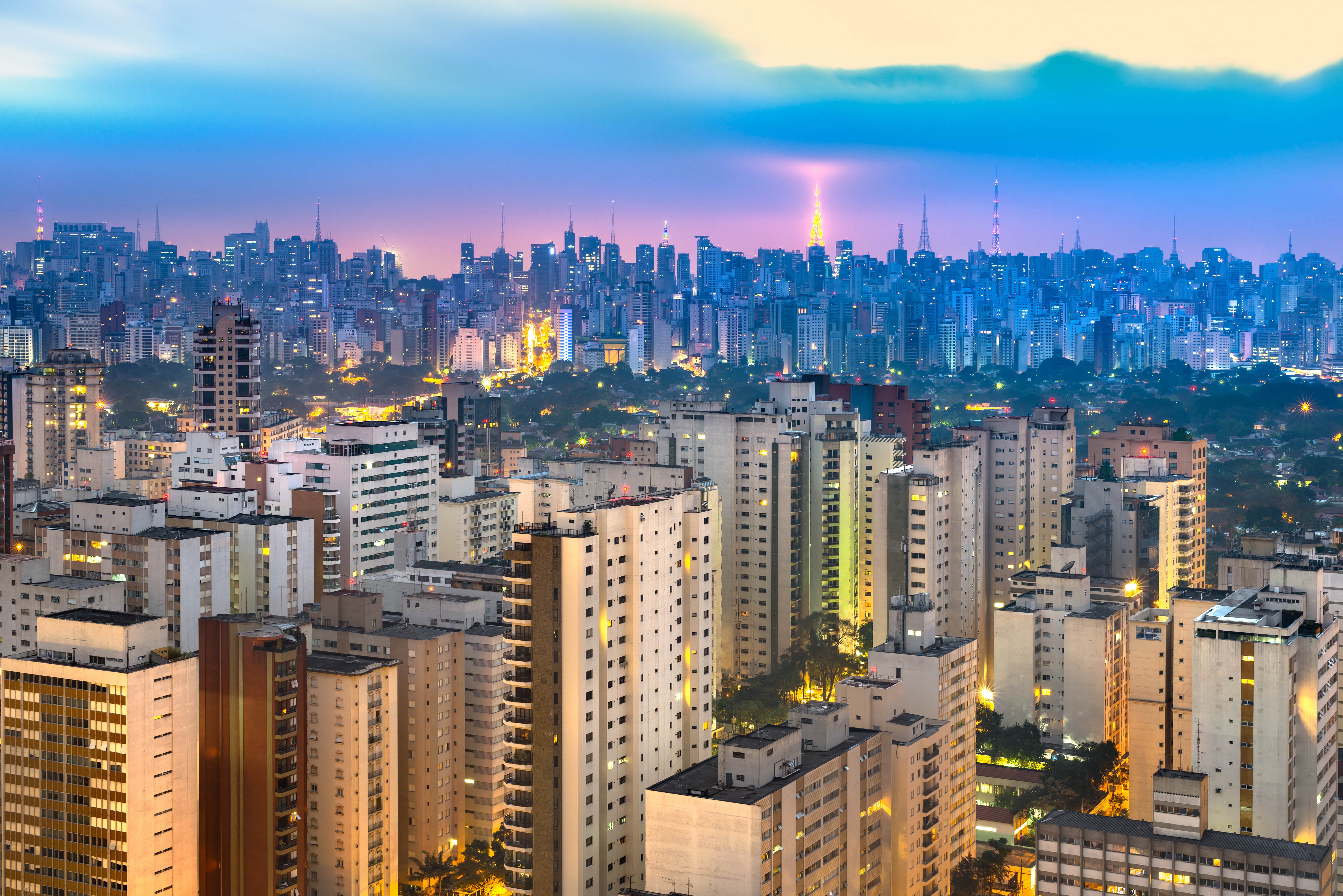 Travel to São Paulo - Sunset with blue and purple sky over São Paulo city with skyscrapers and buildings rising