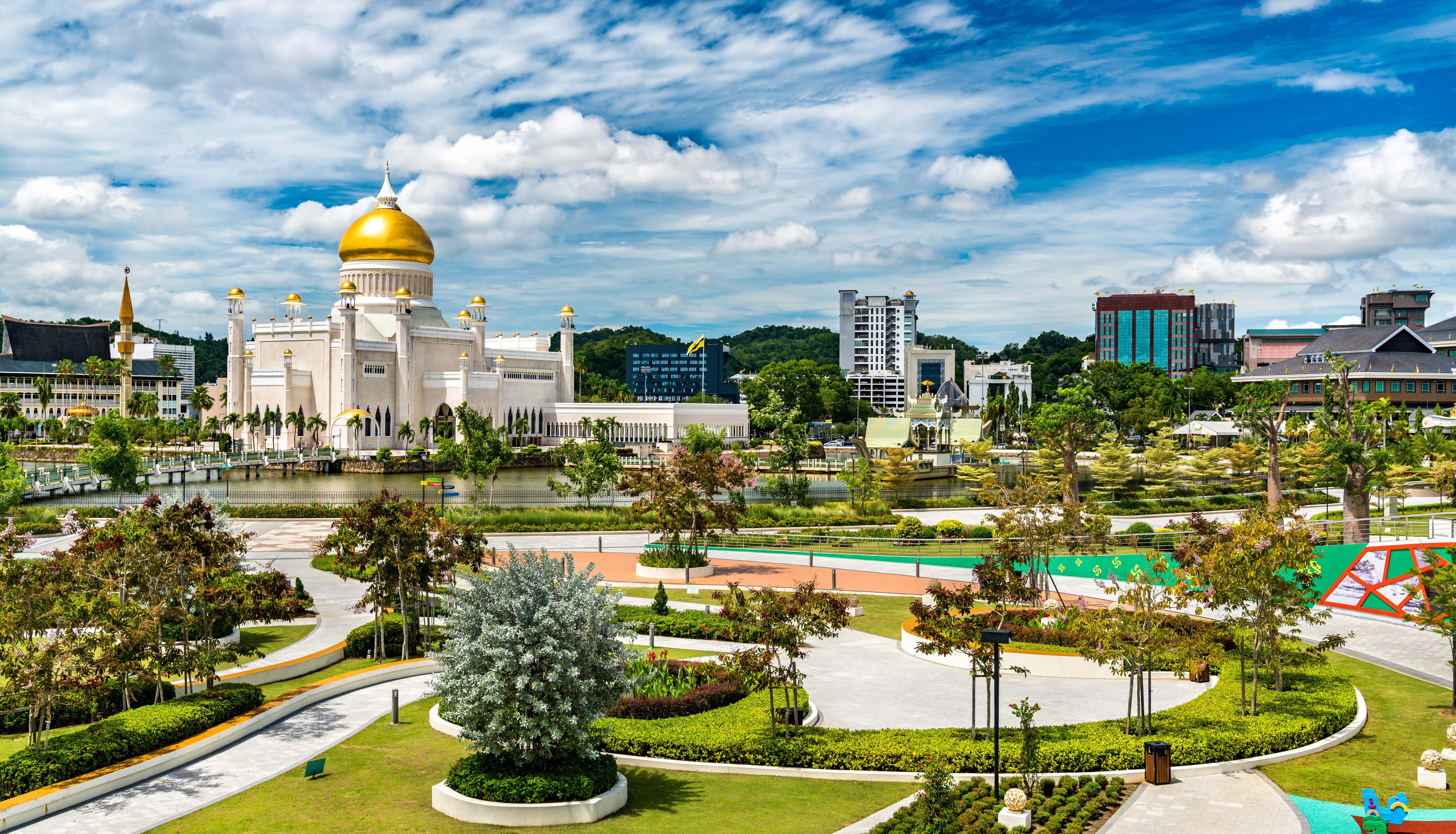 Travel to Brunei - Beautiful verdant park leading up to a large white temple with gold peaks