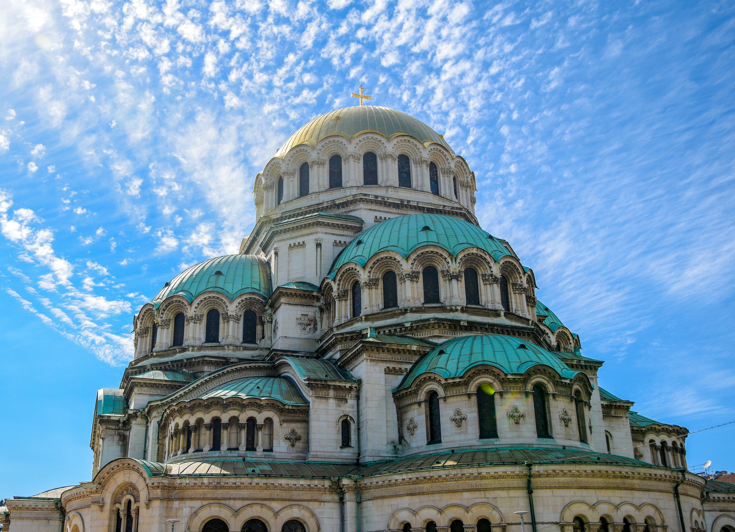 Imponerande Alexander Nevsky-katedralen med gyllene kupoler och gröna tak i Bulgarien mot en molnig himmel.