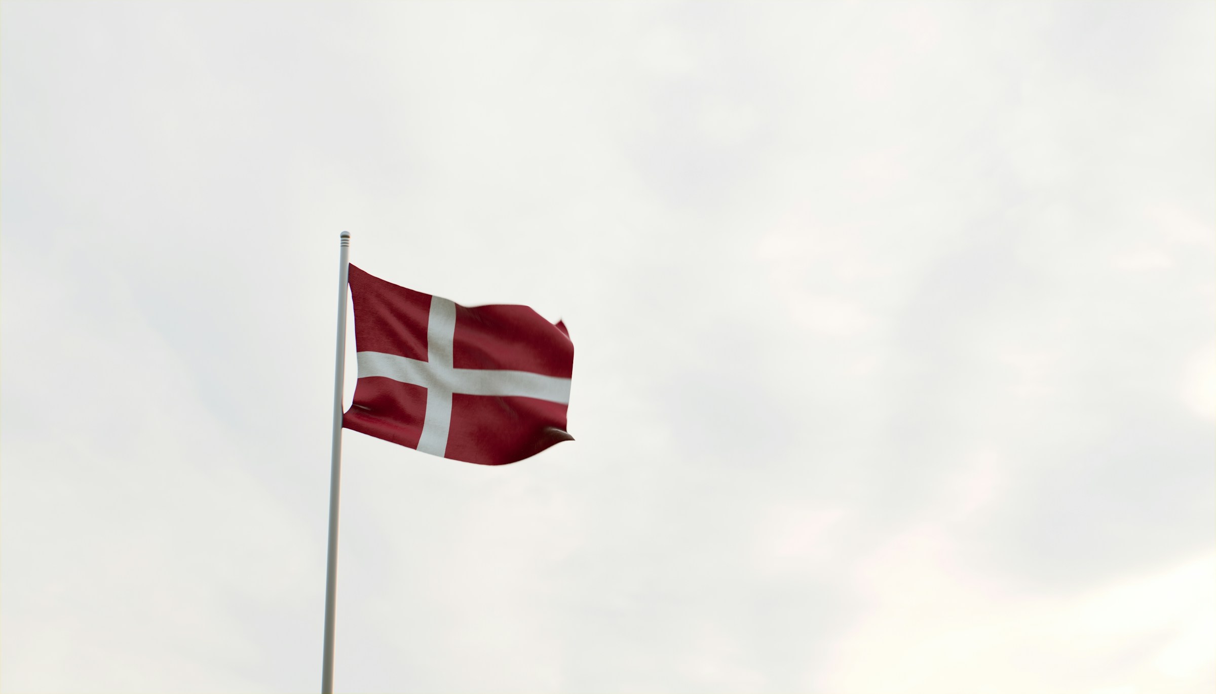 Danska flaggan mot ljus himmel.
