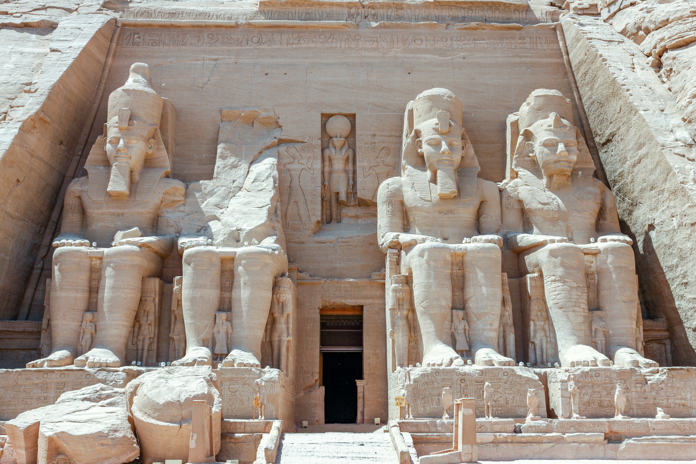 Storslagna kolossala statyer av Ramses II vid Abu Simbel-templets fasad i Egypten under klar himmel."