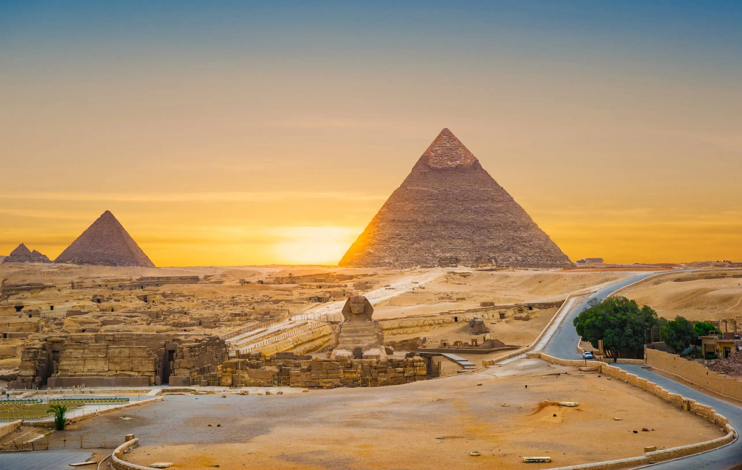 Resa till Egypten - Solnedgång över de antika pyramiderna i Giza, Egypten med klarblå himmel.