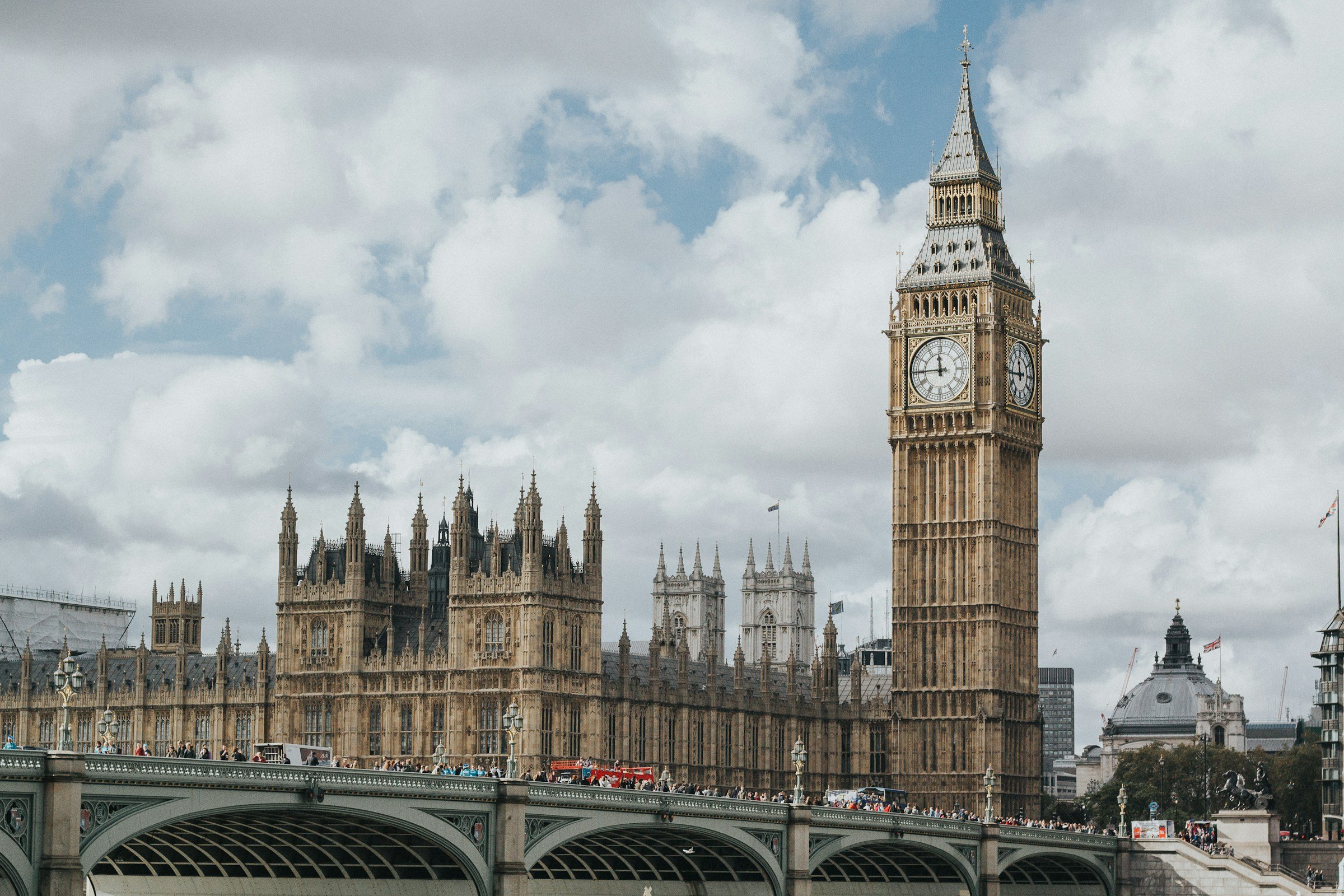 Bild av Big Ben och Westminsterpalatset i London, sett över Westminsterbron under en molnig dag i London.