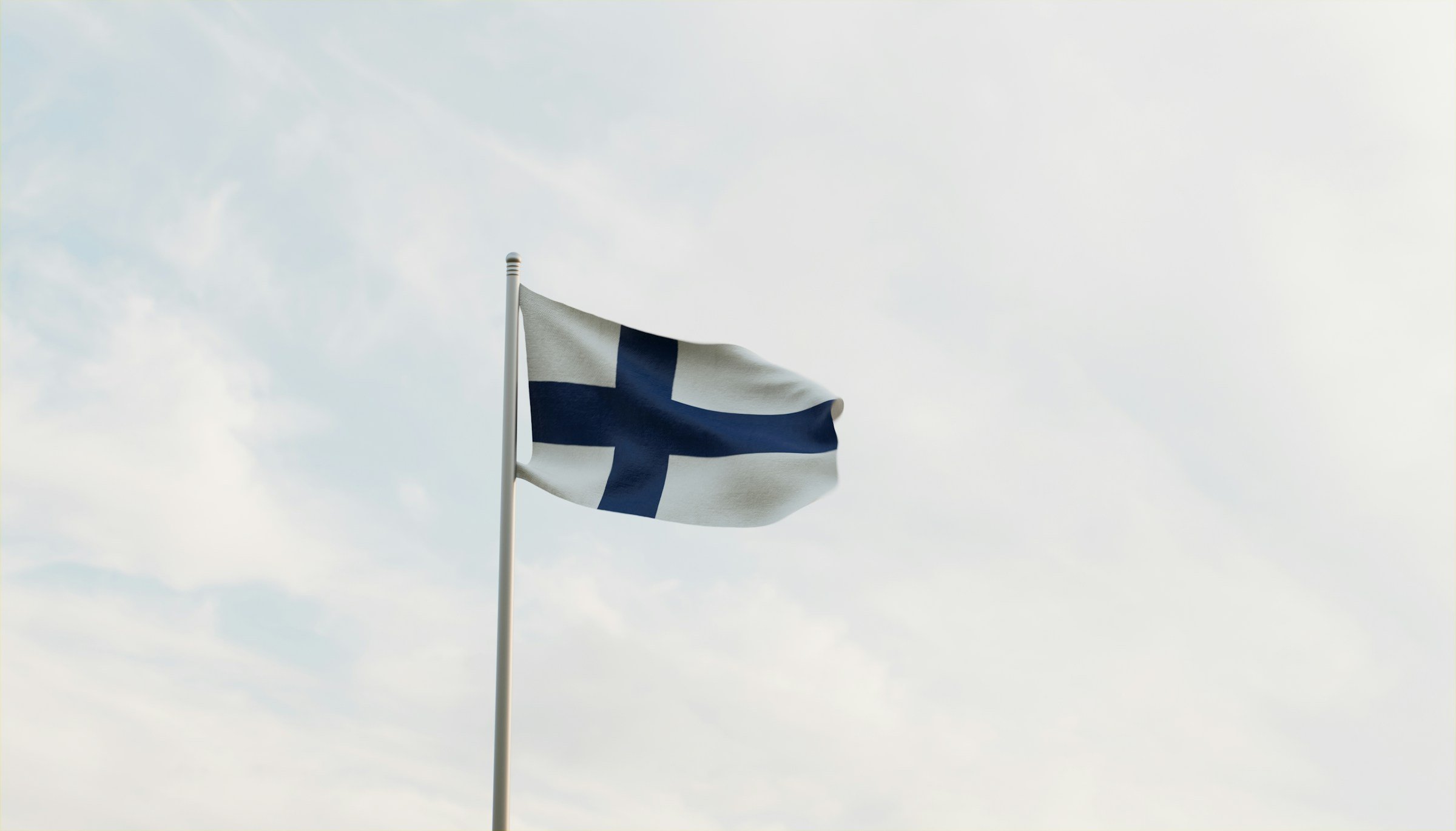 Finlands flagga vajar mot en klar himmel.