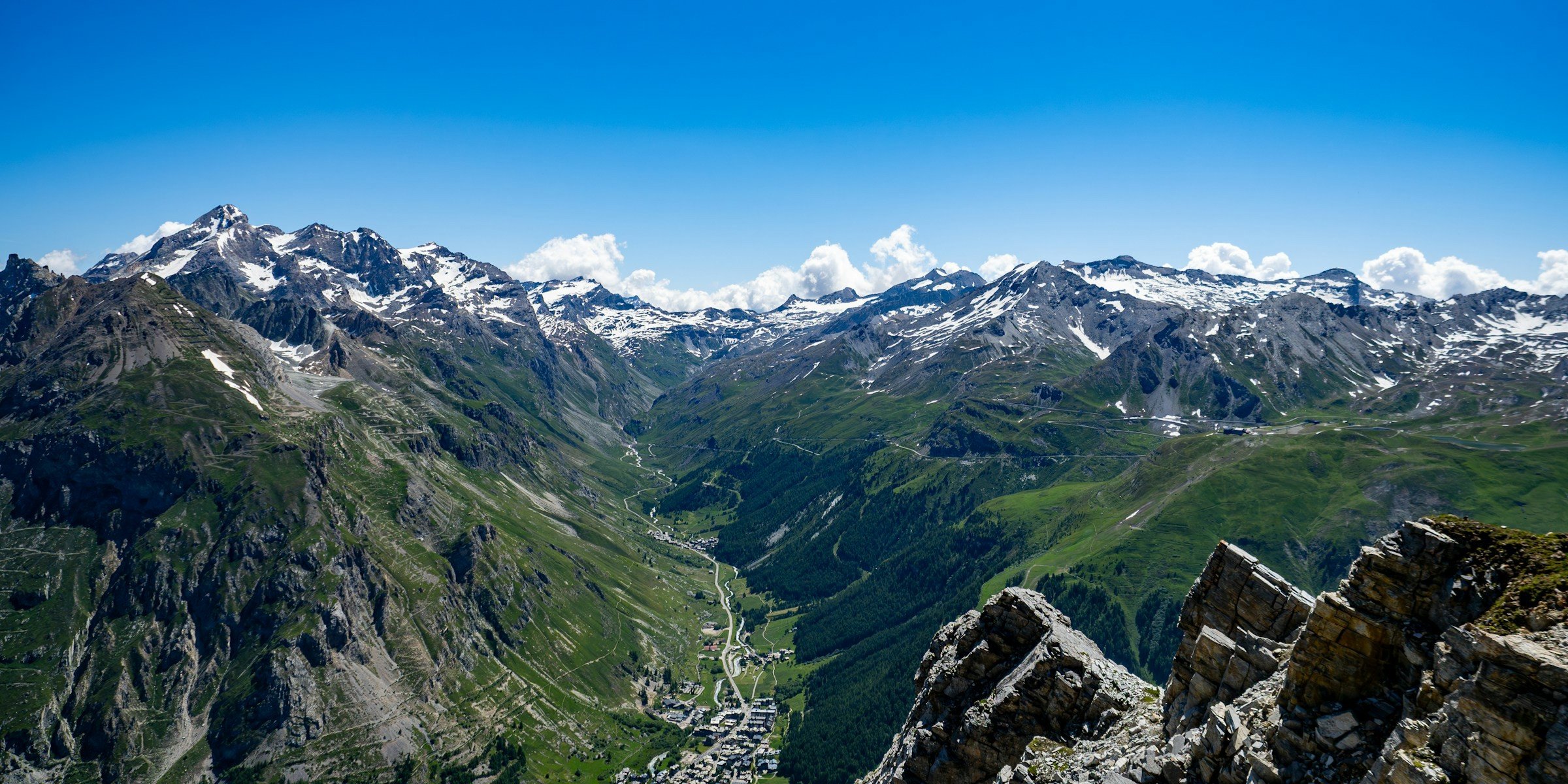 Bergslandskap med snöklädda toppar och en dal under en klarblå himmel i Val d'Isére.