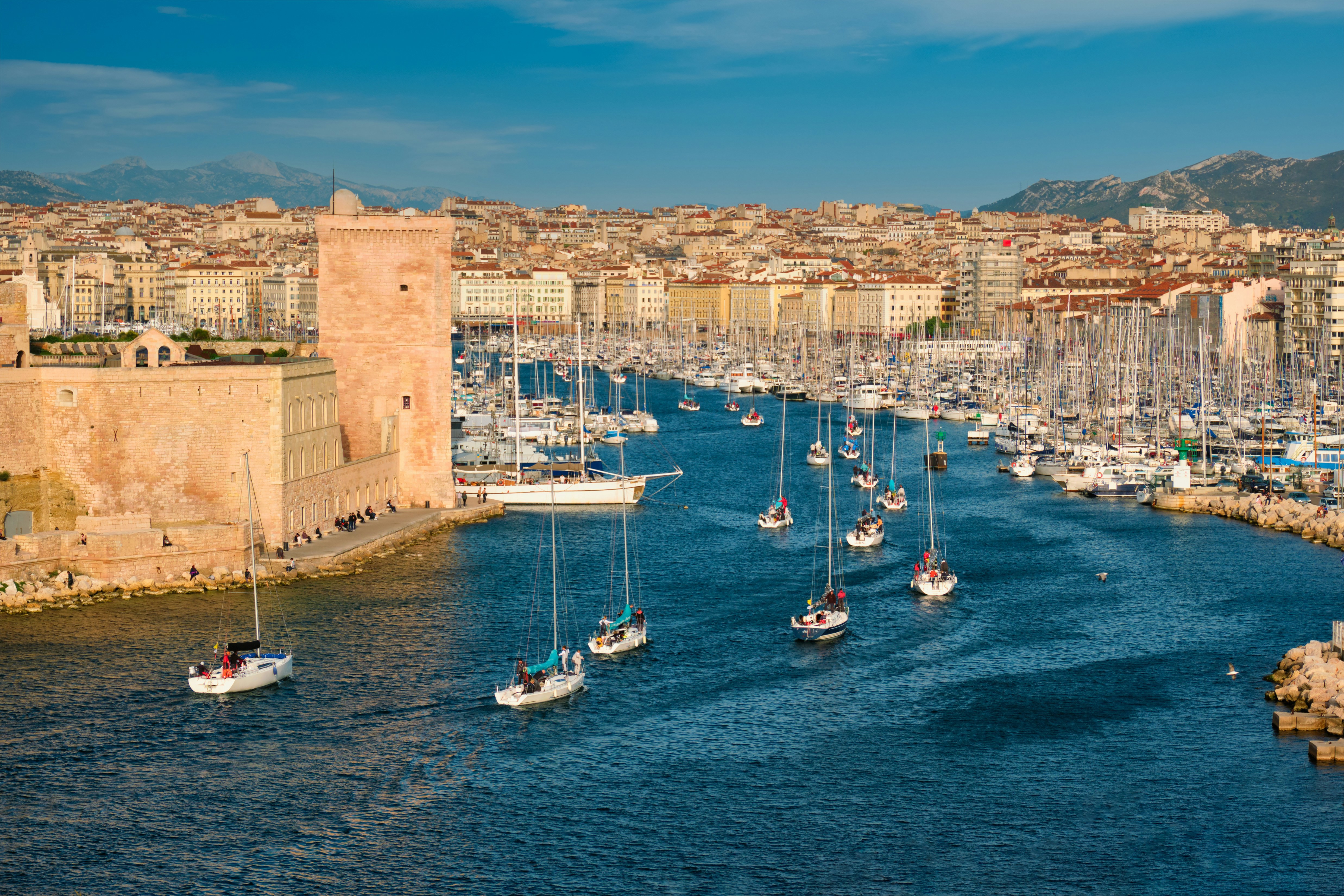 Harbor with boats on their way in with city in the background