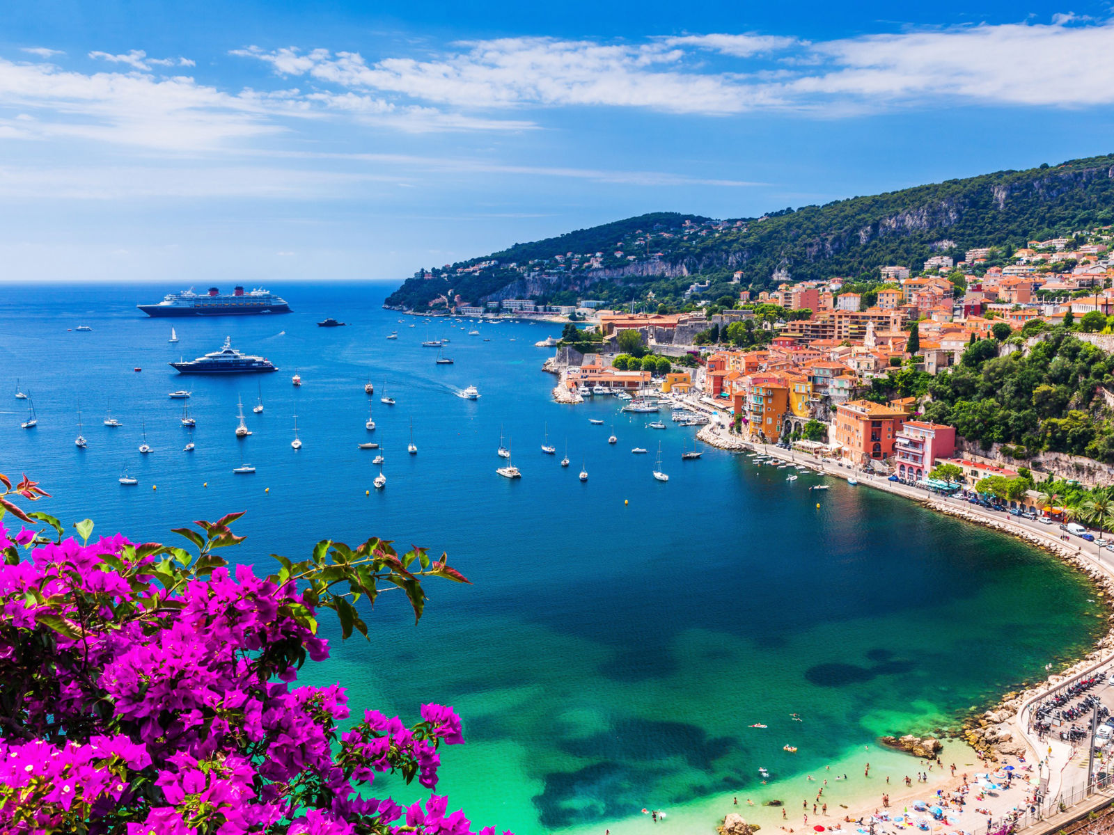 Resa till Franska Rivieran - Bukt med blått hav och båter, grönska och stenstrand runt omkring
