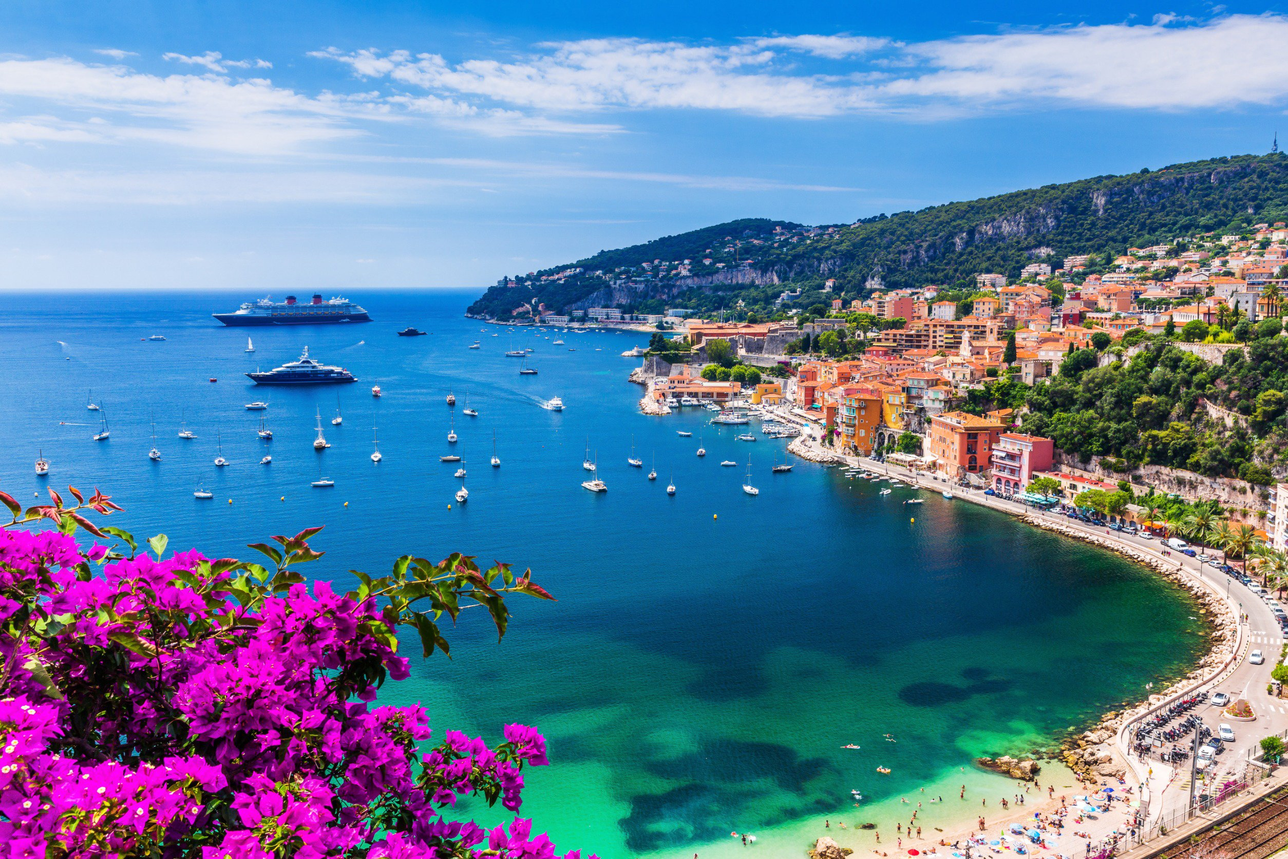 Resa till Franska Rivieran - Bukt med blått hav och båter, grönska och stenstrand runt omkring