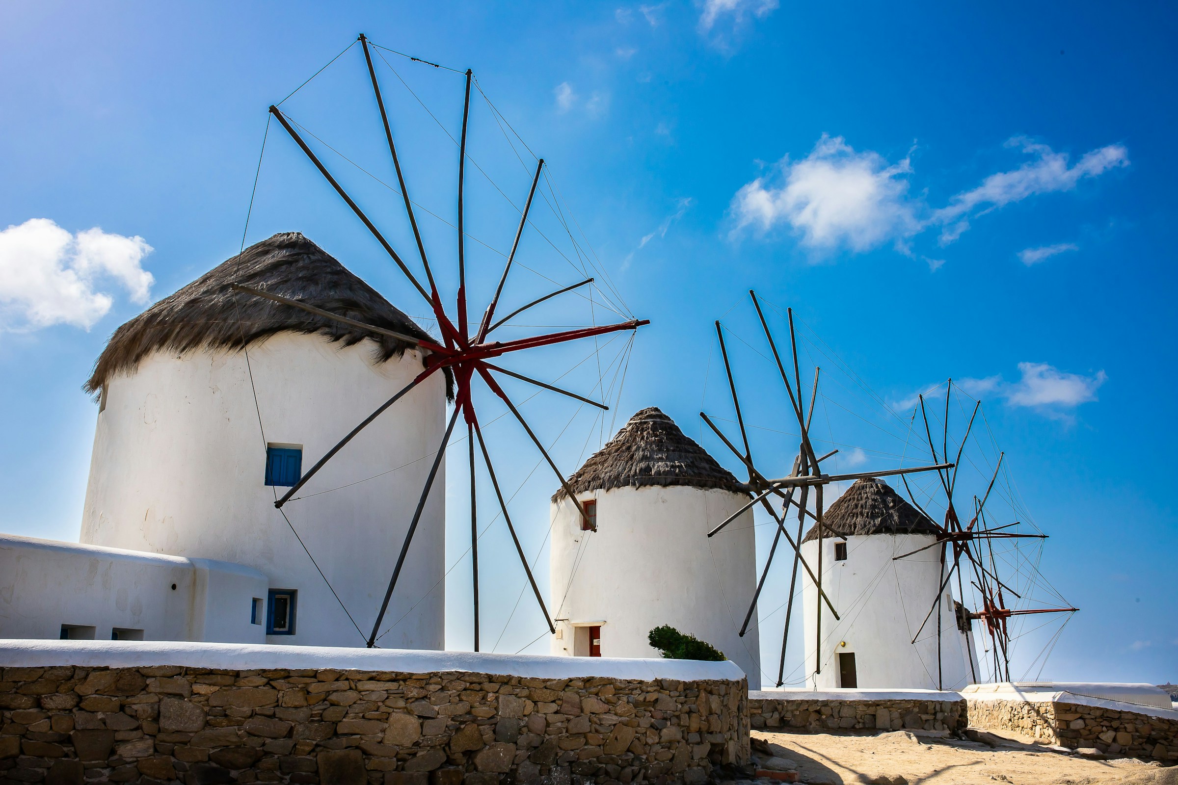 Vita traditionella väderkvarnar mot en klarblå himmel på Mykonos, Grekland.