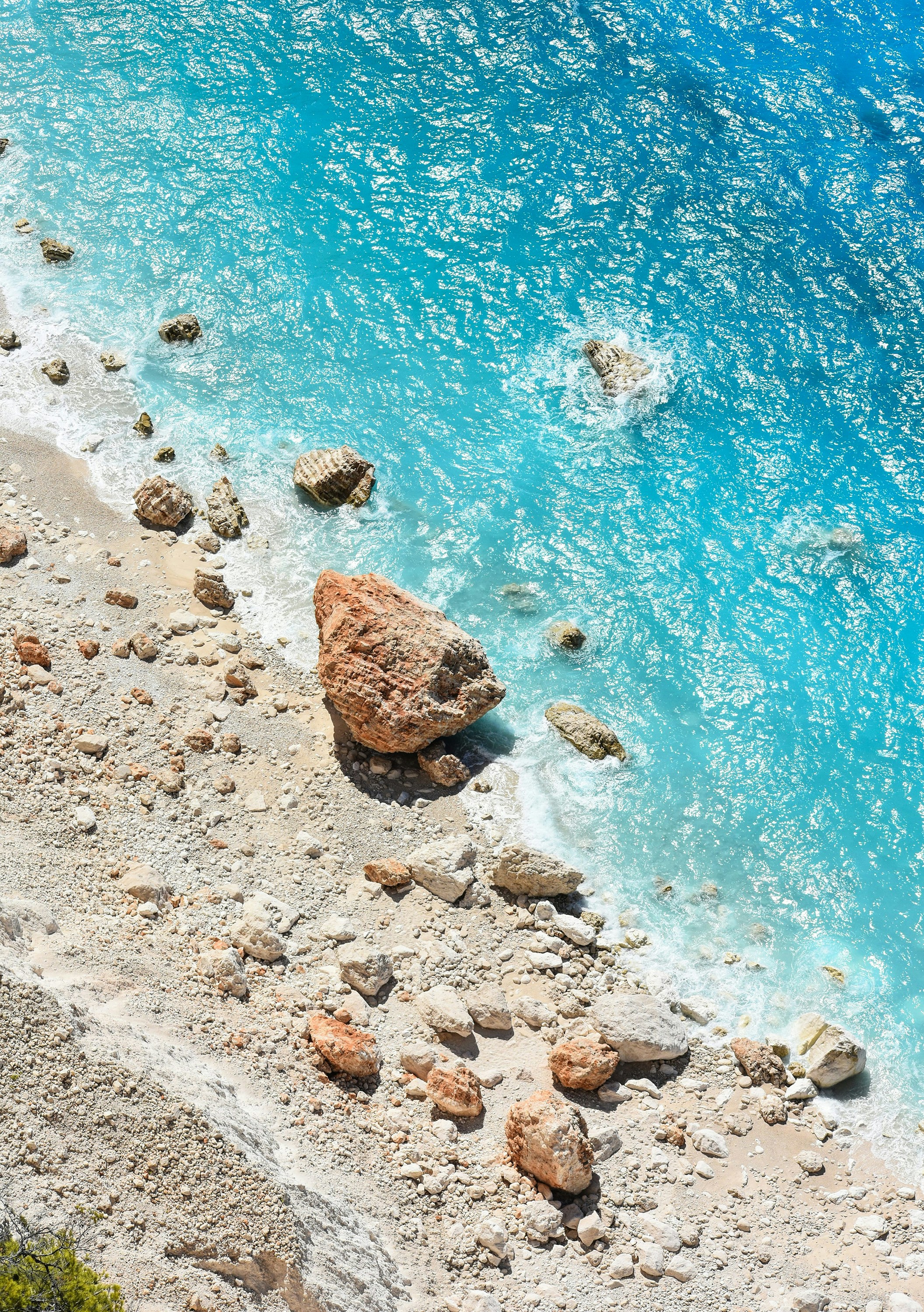 Klippig strand med turkos vatten och stenar på ön Zakynthos i Grekland