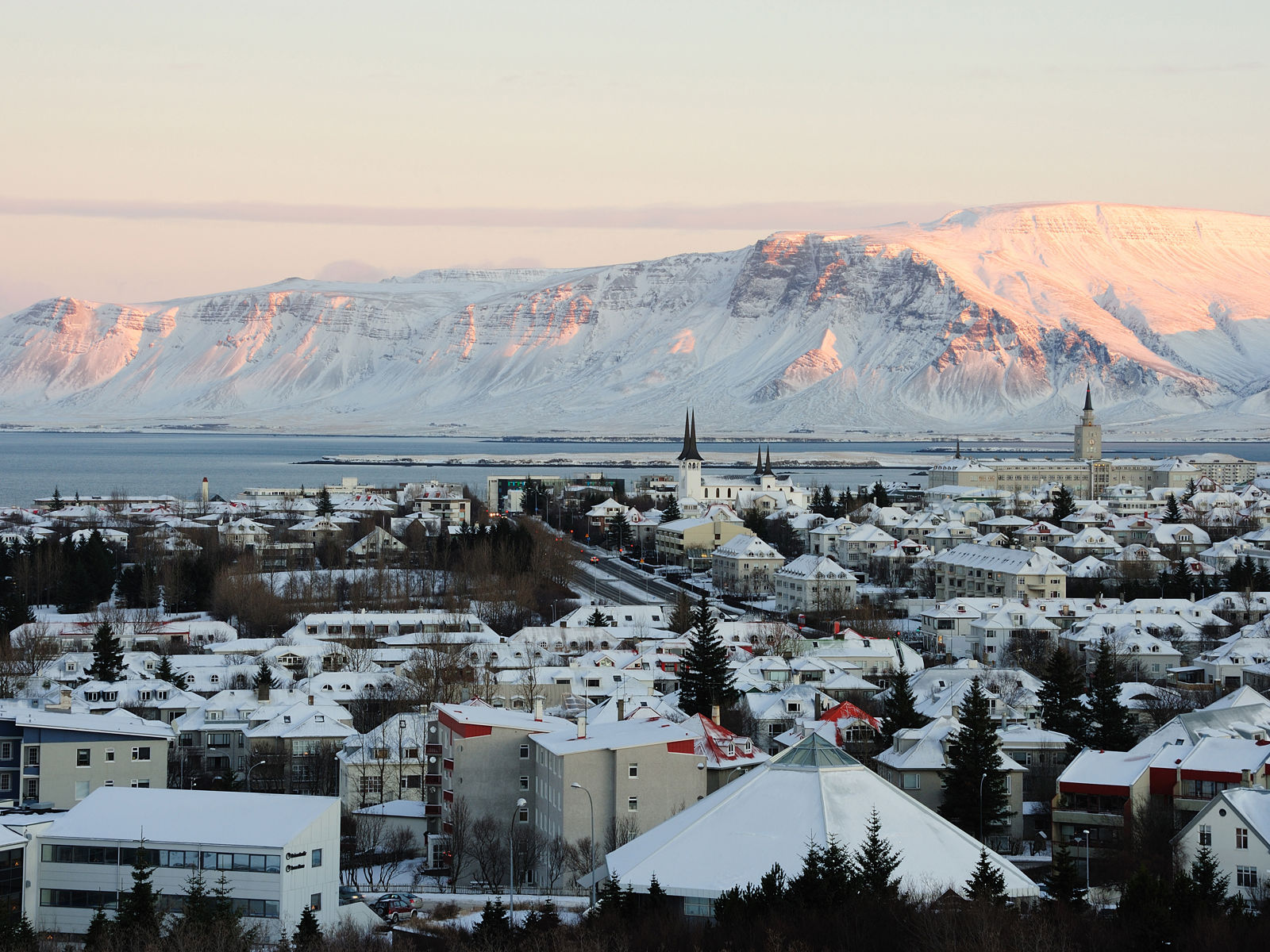 View of Reykjavik city with mountains in the background during a sunset