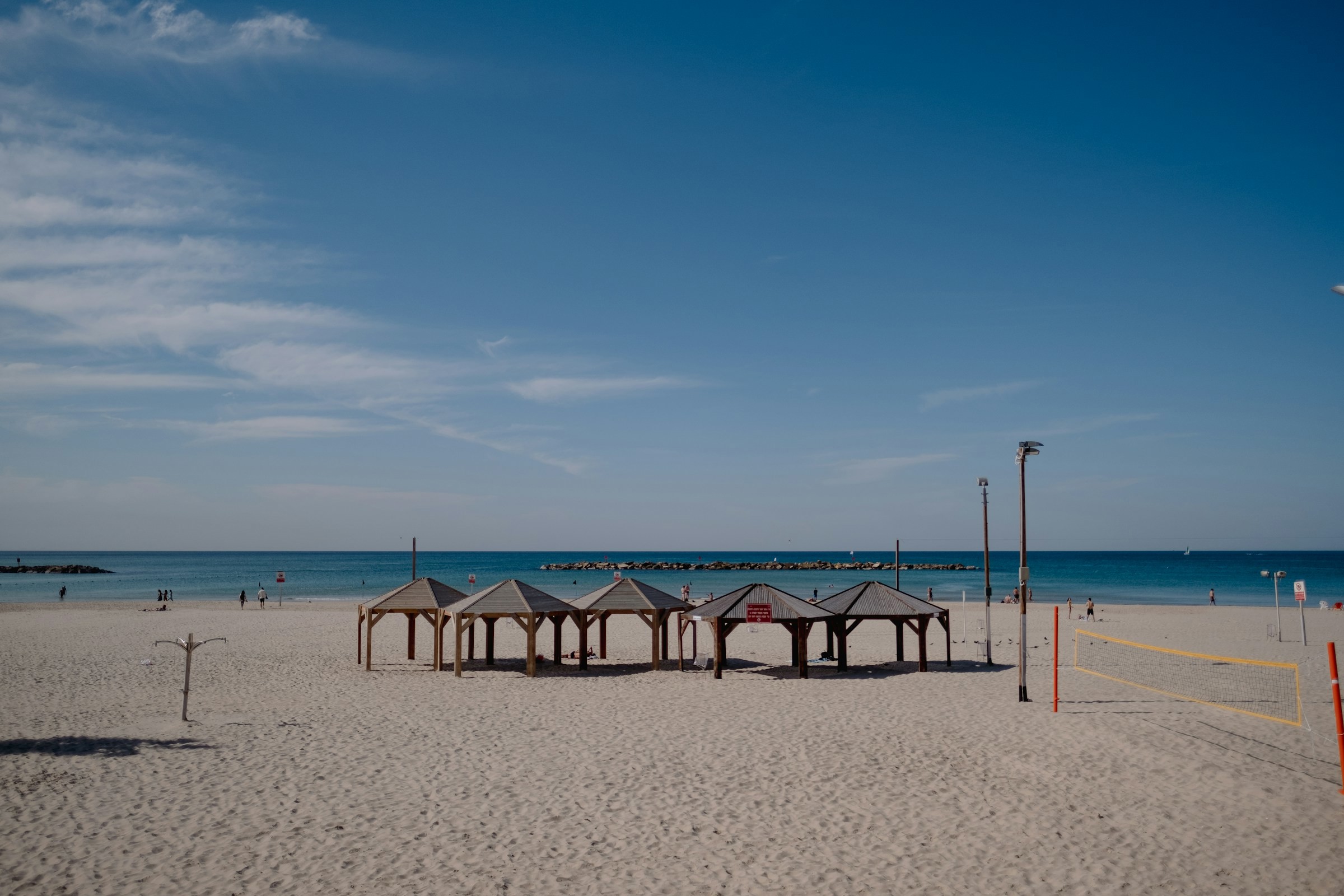 Strand med små tält i Tel Aviv som möter det döda havet och en blå himmel