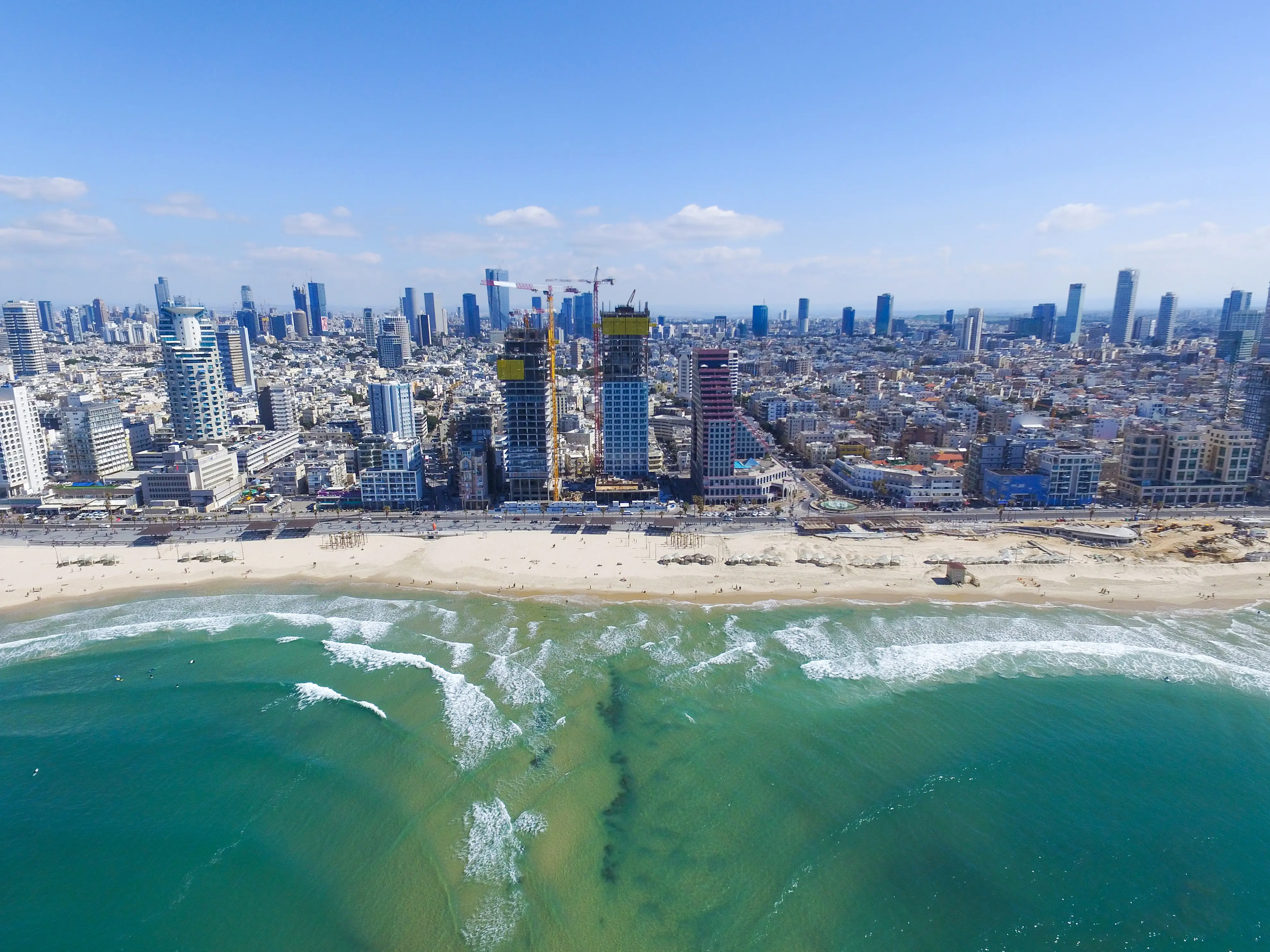 Resa till Tel Aviv - Flygfoto av Tel Aviv vid kusten med skyskrapor, strand och klart blått vatten.