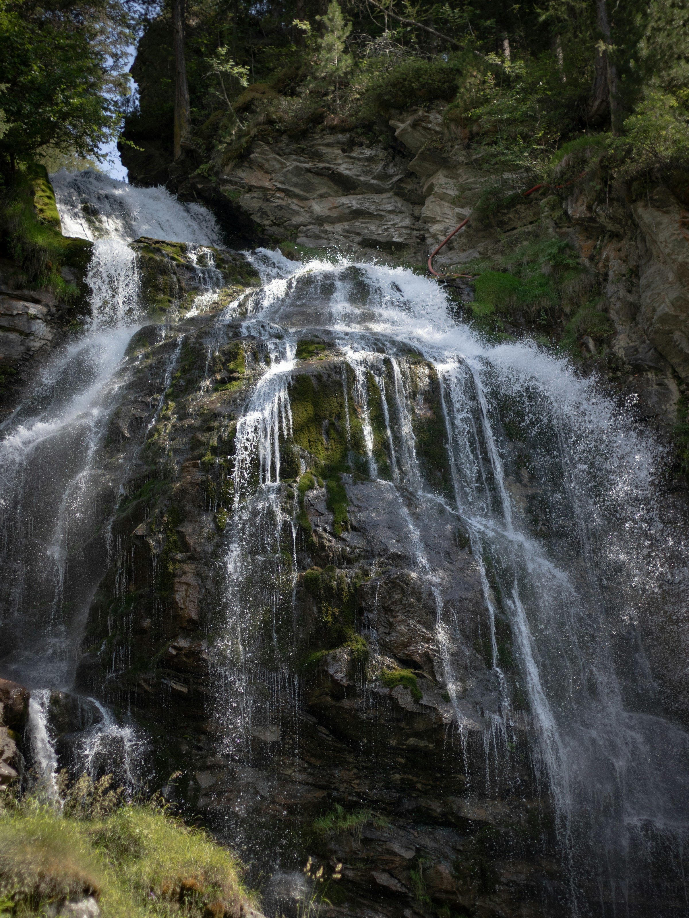 View from below on a beautiful waterfall in a forest in Champoluc, Italy