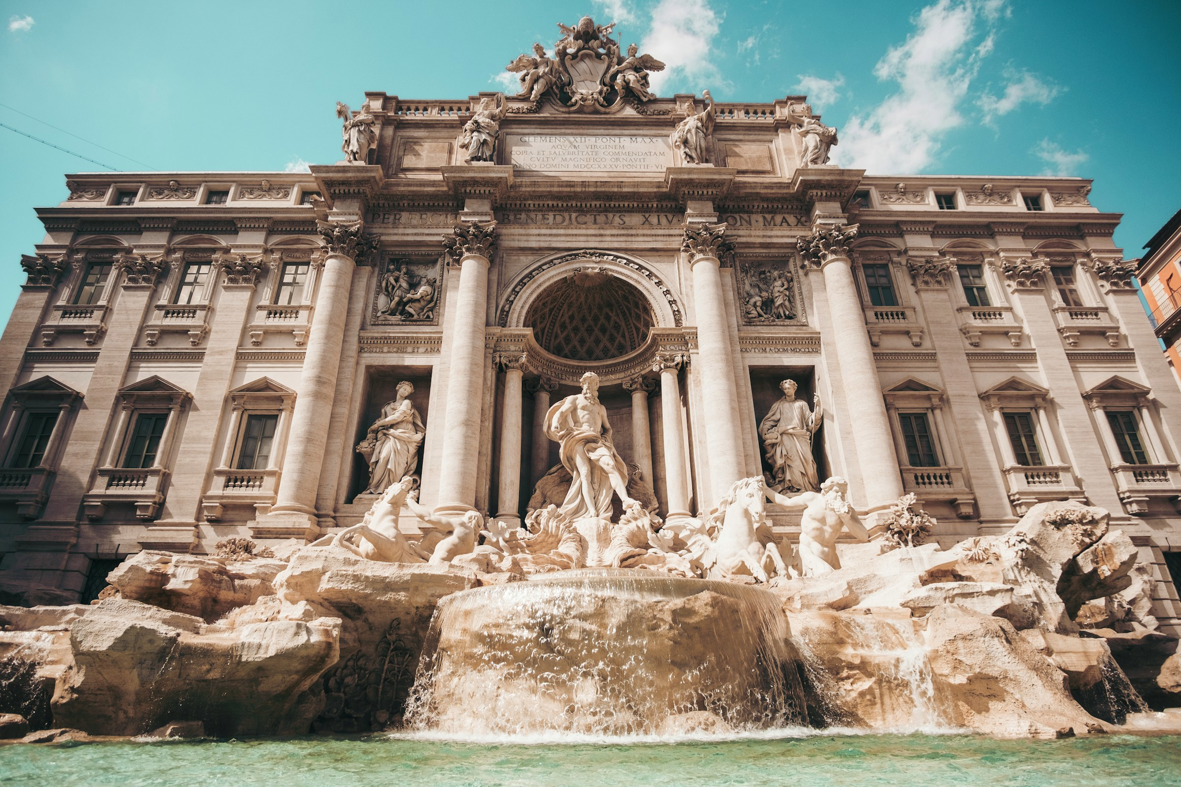 Fontana di Trevi, den berömda barock fontänen i Rom, med skulpturer och kristallklart vatten på en solig dag, en populär turistattraktion.