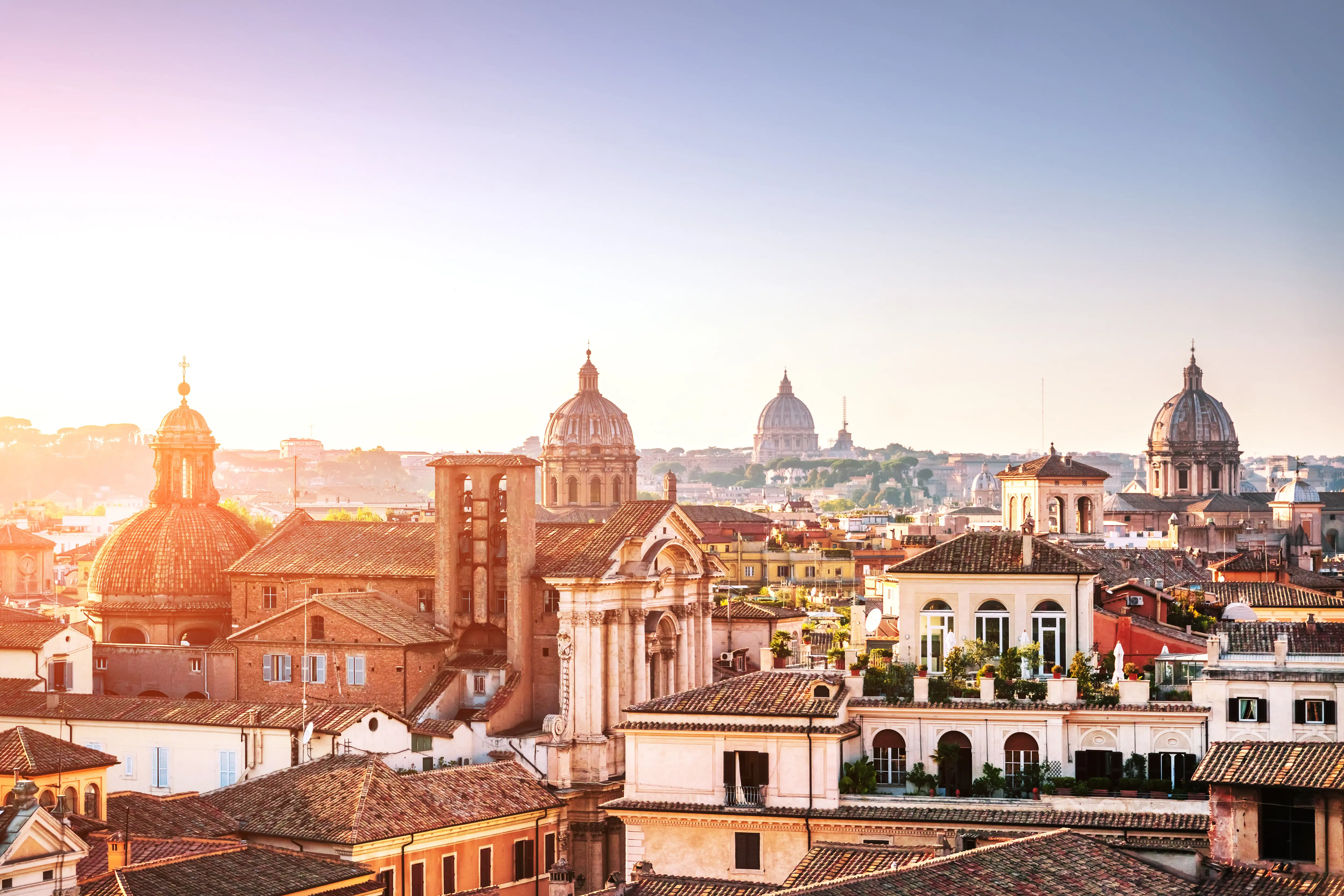 Resa till Italien - Soluppgång över romerska stadssilhuetten med historiska byggnader och kupoler i Italien.