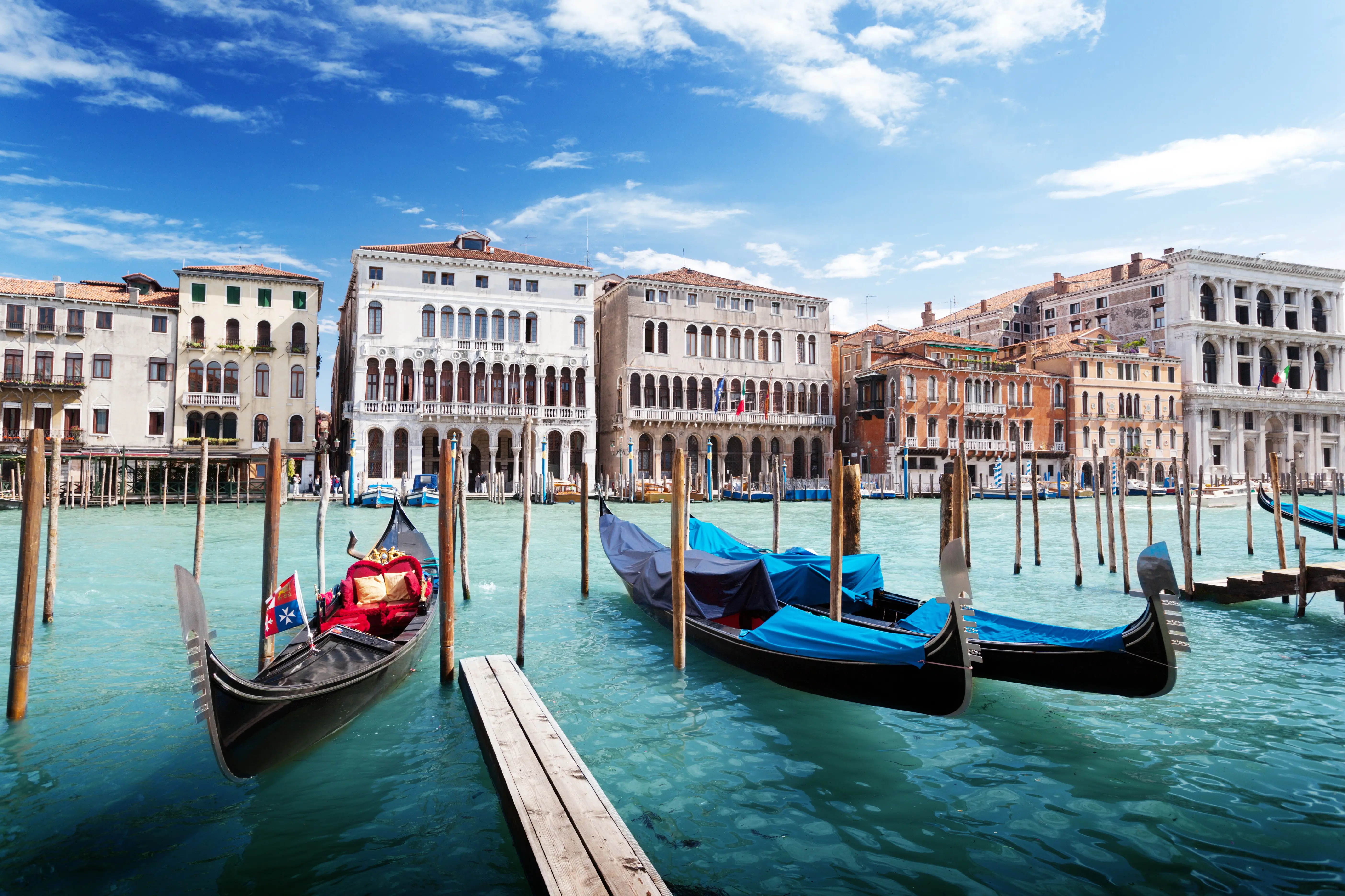 Resa till Venedig - Gondoler förtöjda längs Canal Grande med historiska byggnader i bakgrunden i Venedig, Italien.