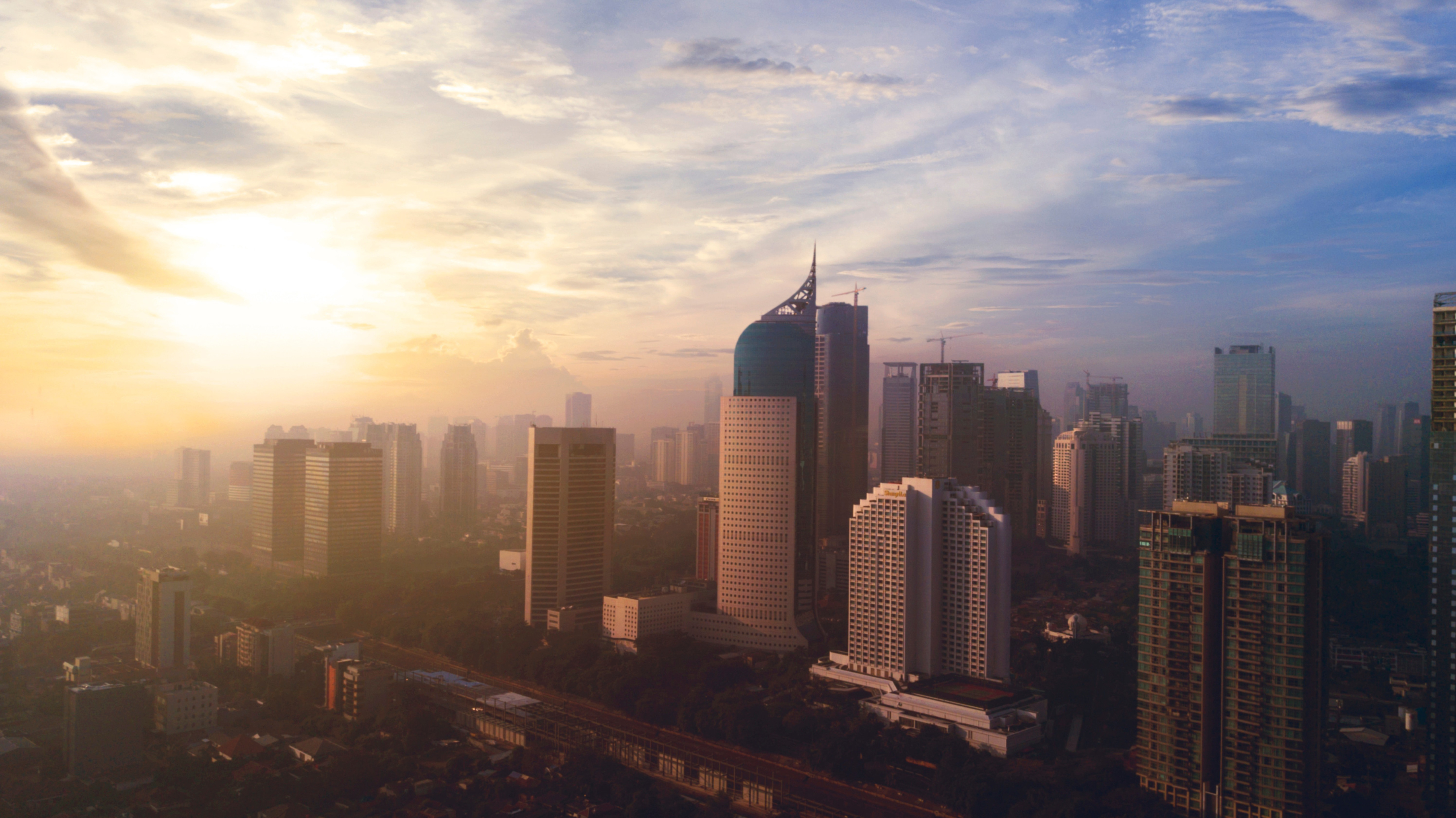 Travel to Jakarta - Sunrise over the skyline of Jakarta but skyscrapers meeting a blue sky