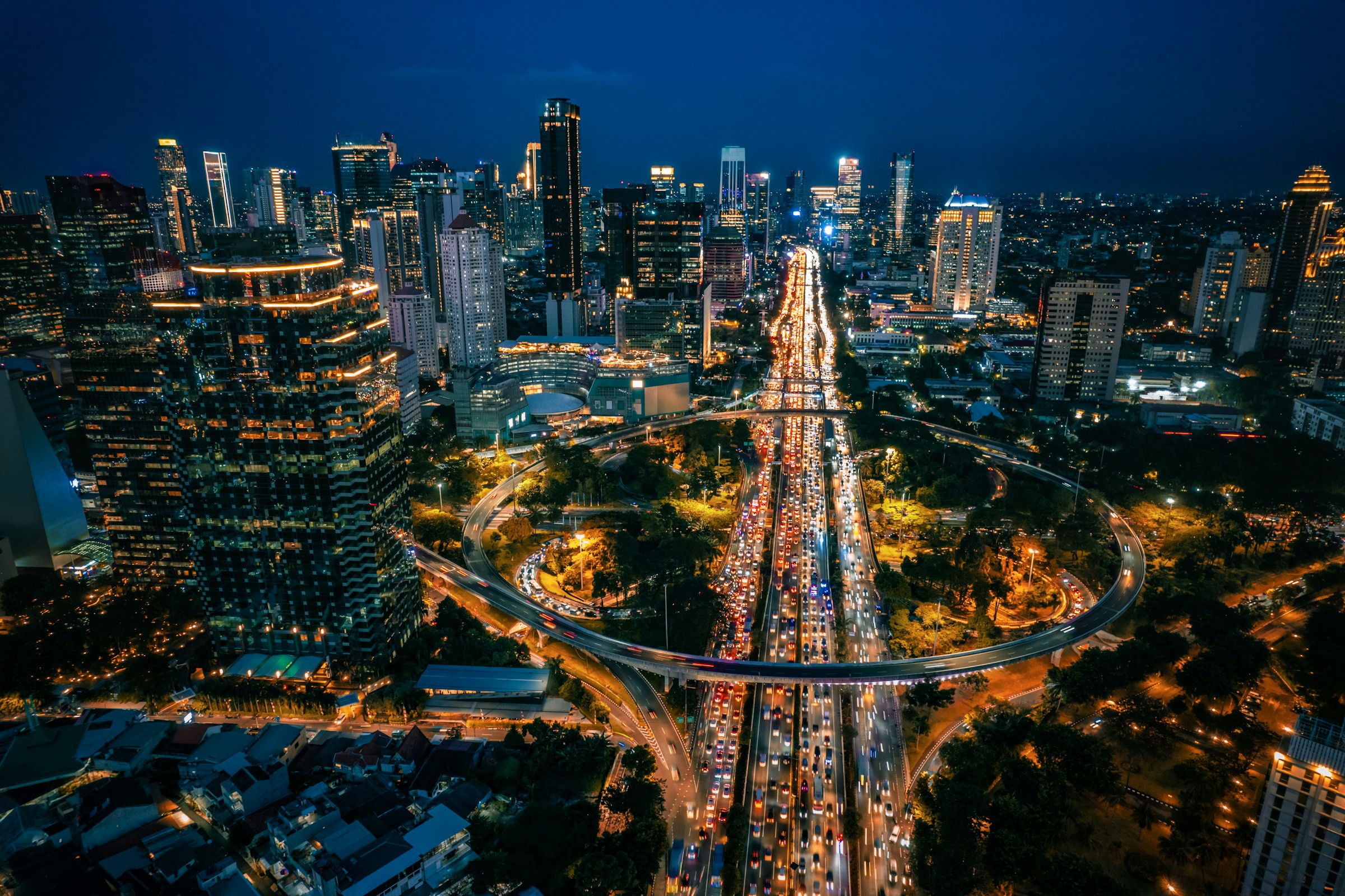 Vy över Jakarta-stad under nattetid med staden som lyses upp av belysning, trafik och skyskrapor i bakgrunden