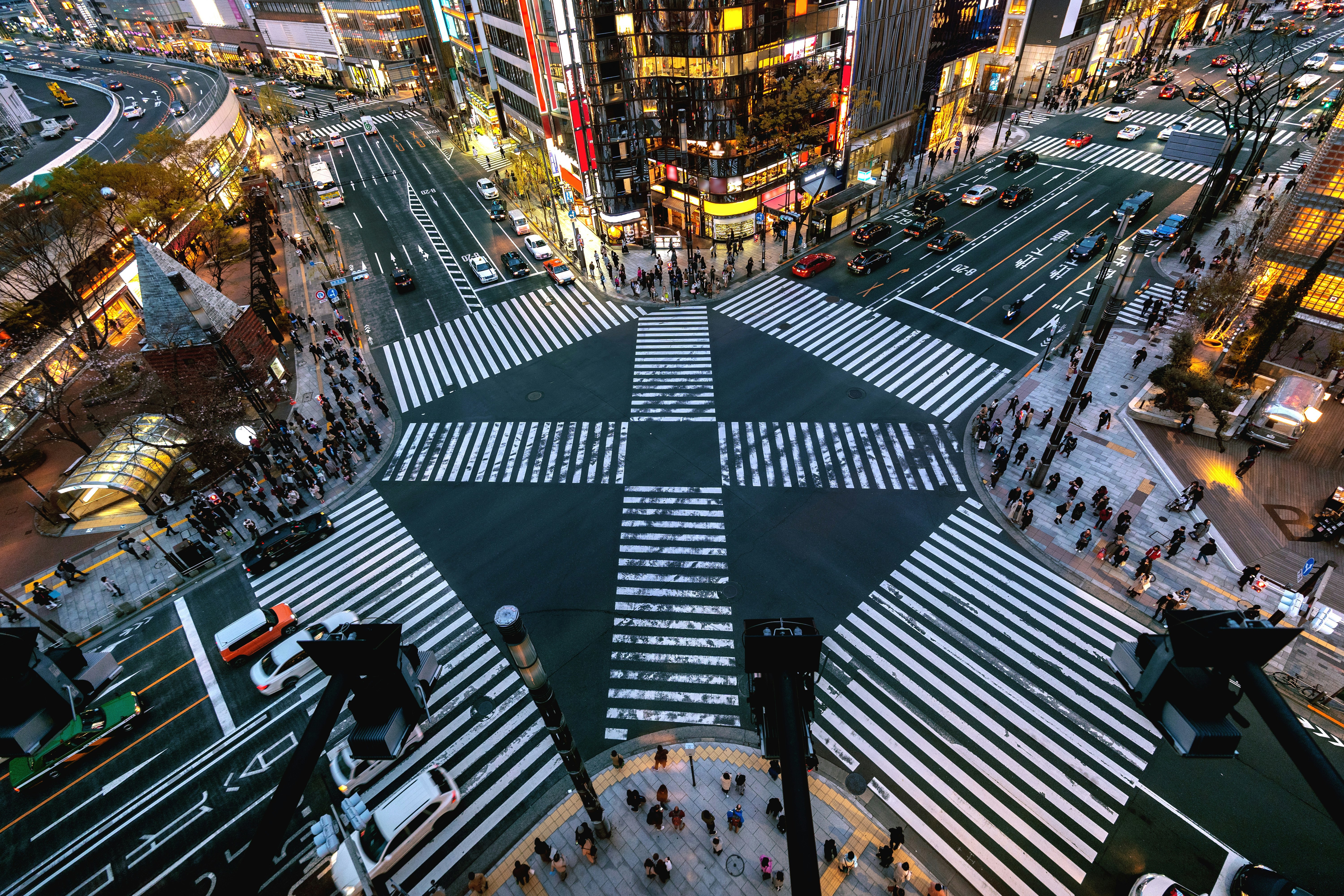 Vy ovanifrån på kände Shibuya korsningen i centrala Tokyo med trafik, folk och belysning runt omkring