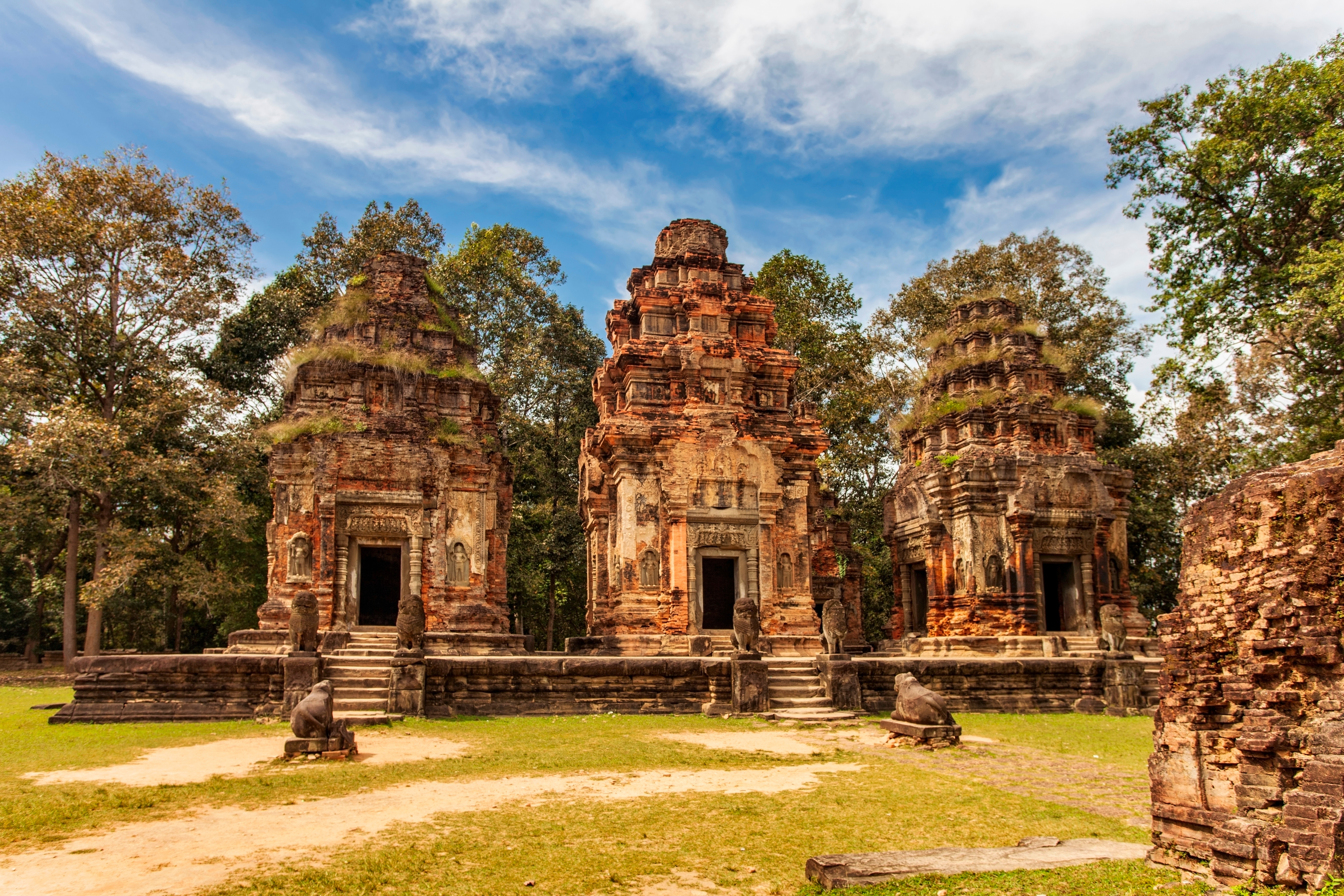 Resa till Kambodja - Gamla tempelruiner i Angkor Wat omgiven av grönska under en klar himmel i Kambodja.