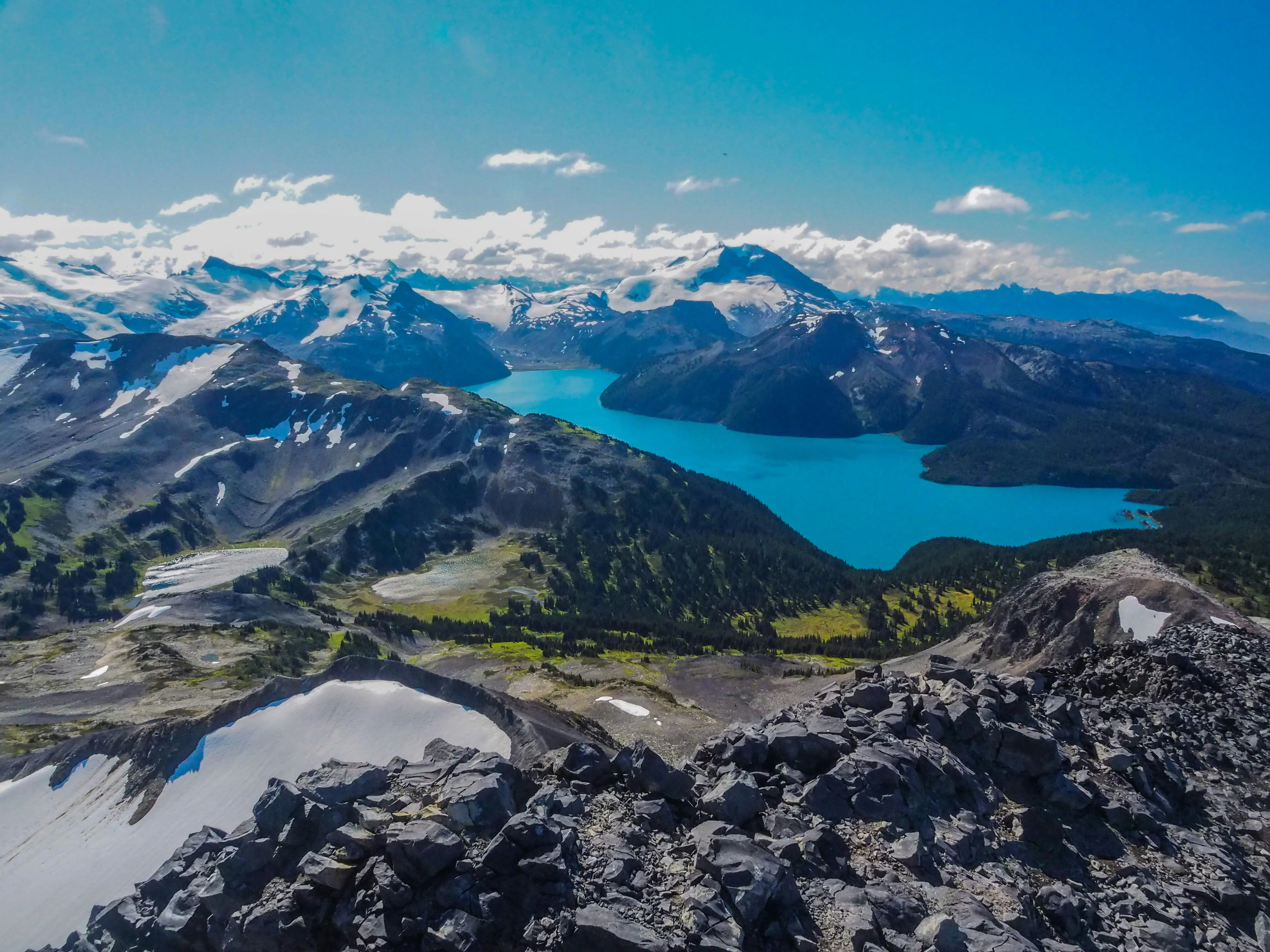 Resa till Whistler - Panoramavy över turkos bergssjö omgiven av snöklädda toppar och klippiga terränger i ett bergslandskap