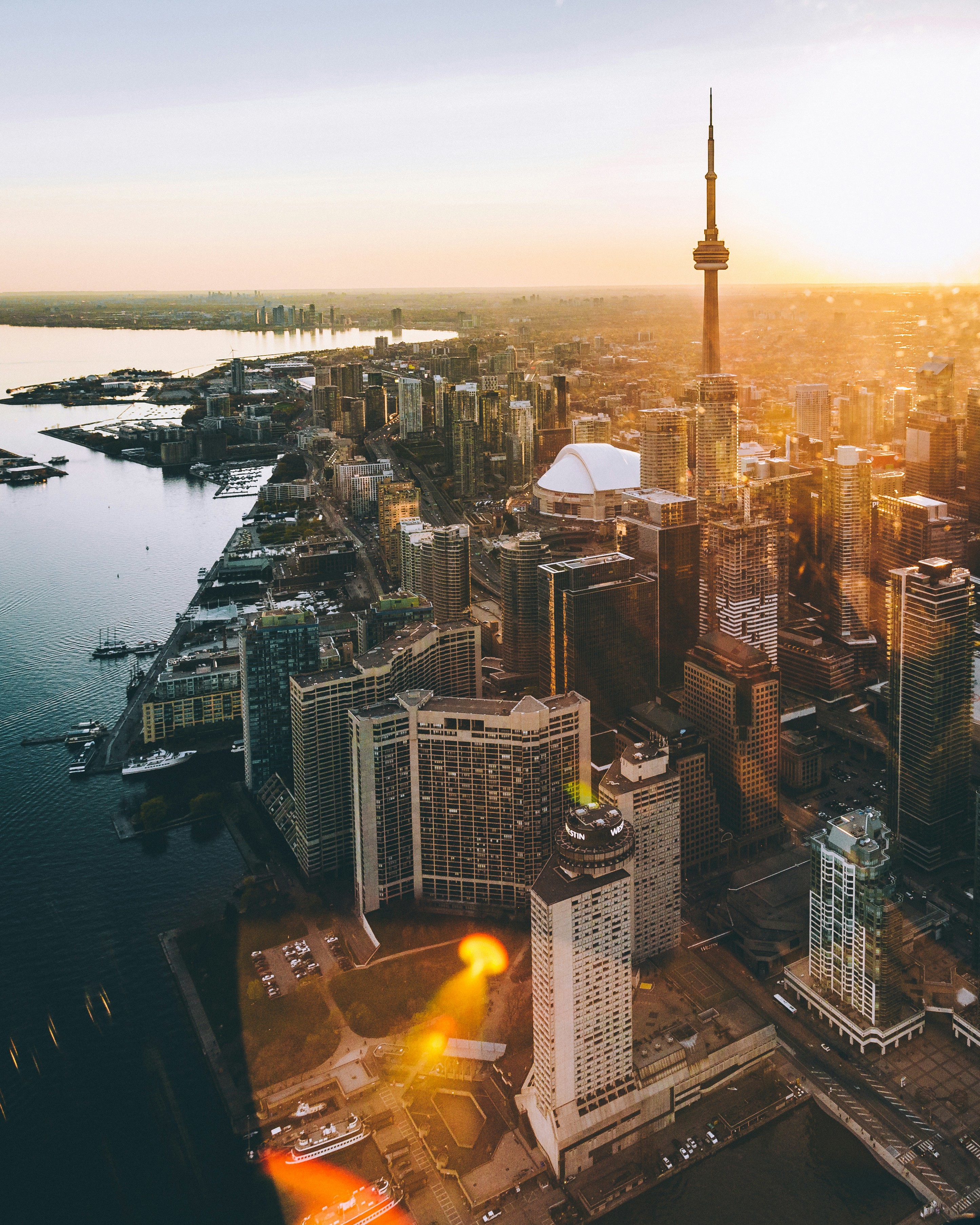 Vy ovanifrån på kustkanten av Toronto stad med byggnader som sträcker sig fram till en solnedgång