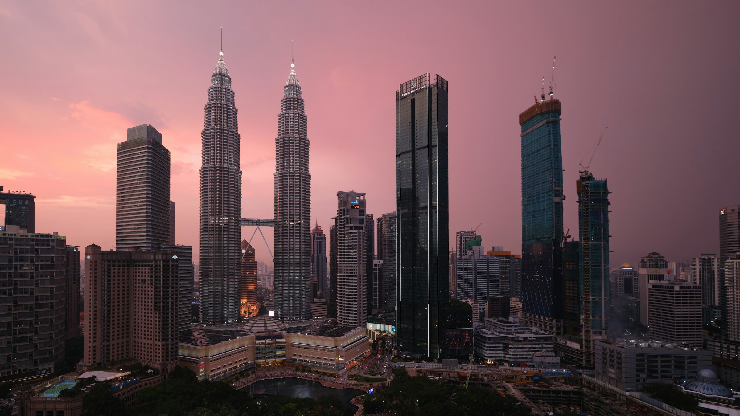 Soldnedgång med rosa himmel över Kuala Lumpur och PETRONAS Twin Towers