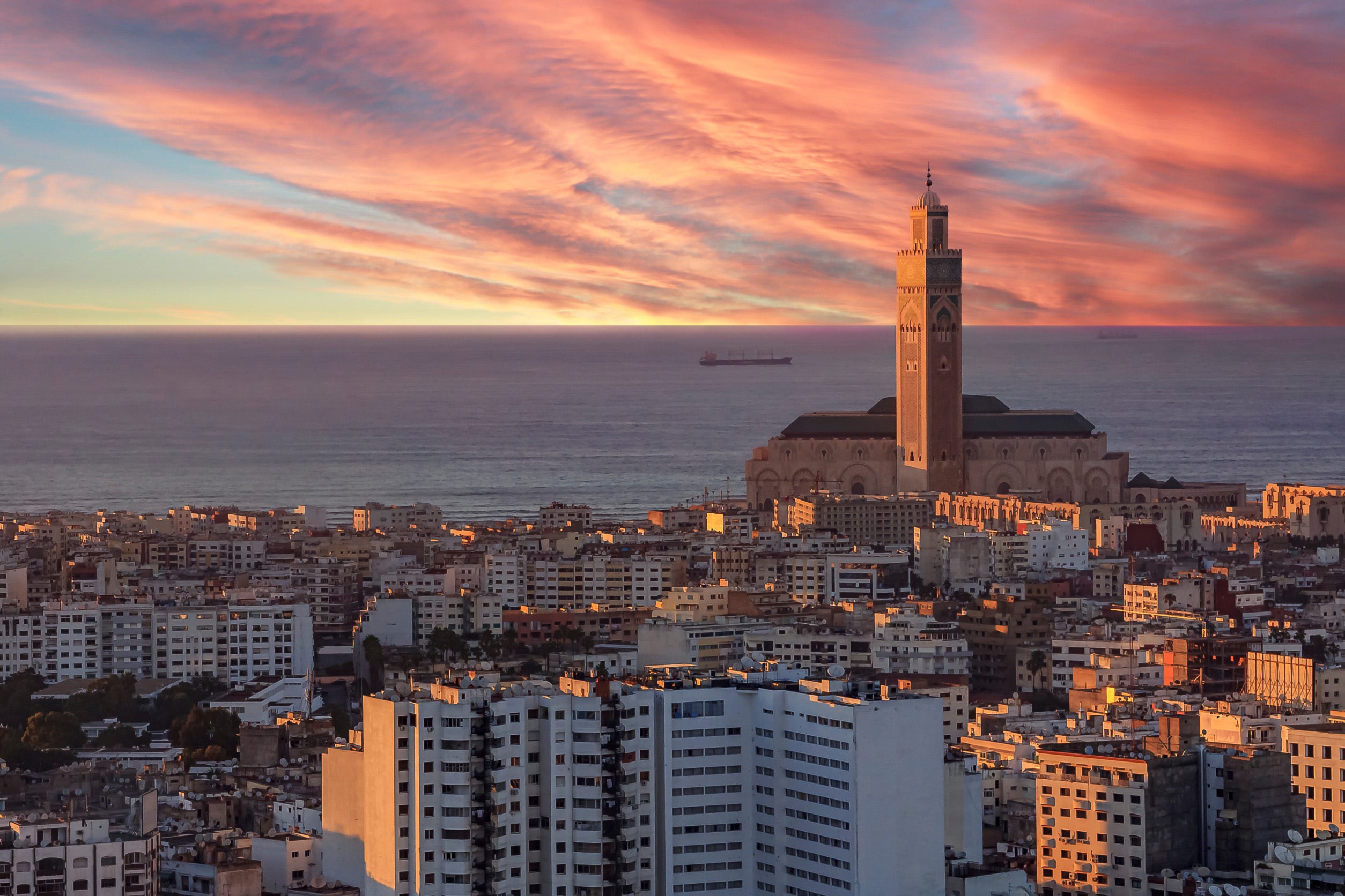 Vacker röd solnedgång över Casablanca stad med känd traditionell moské i bakgrunden