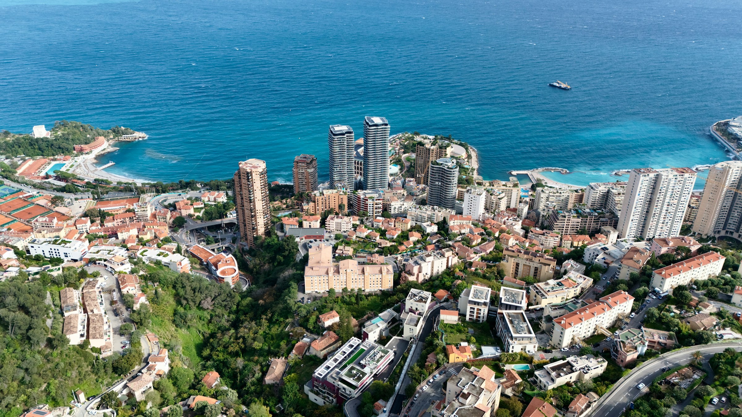 Panoramavy över Monaco-stad och hamn vid turkosblått hav och båtar som kommer in