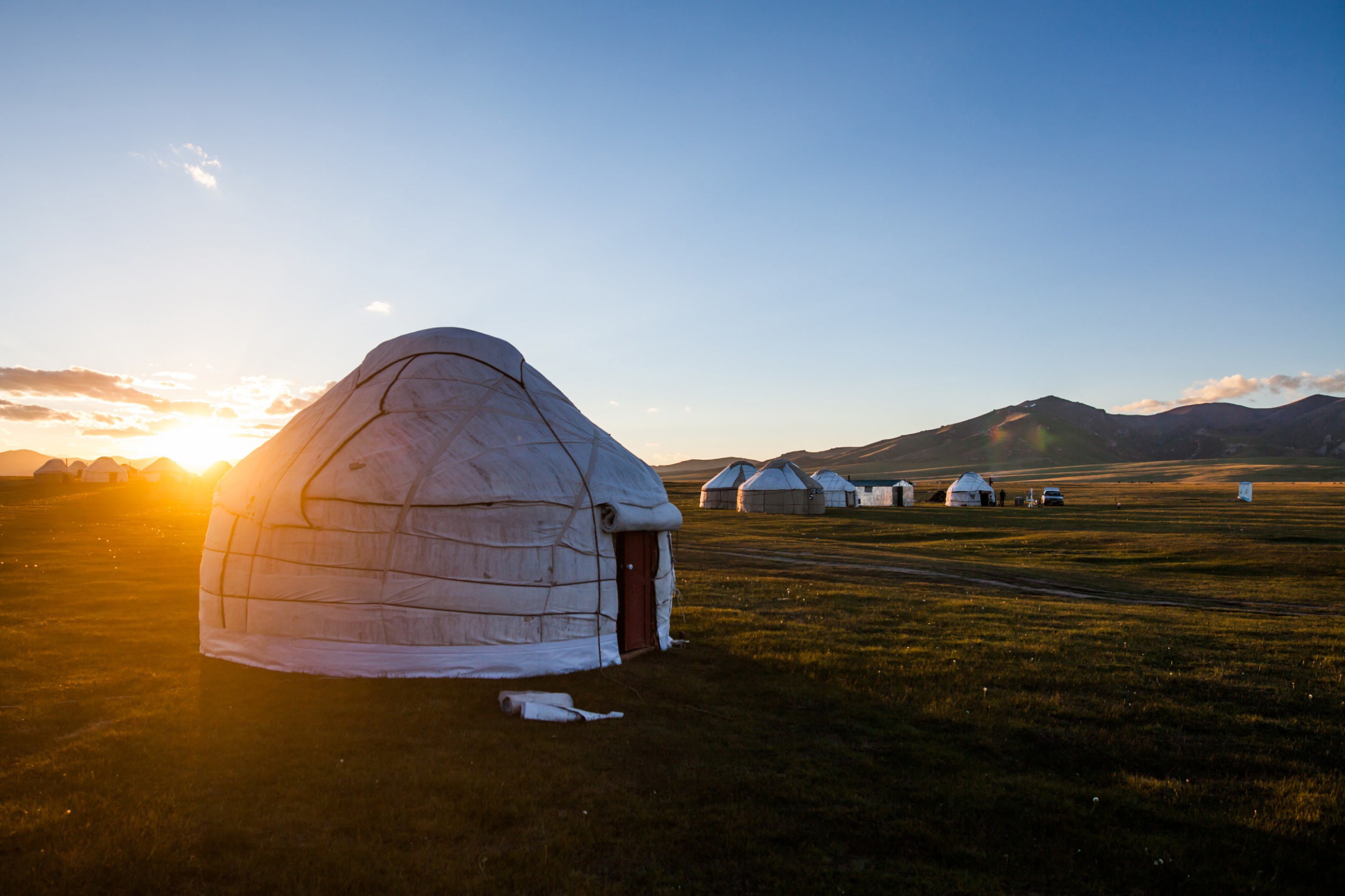 Classic Mongolian hut on a plain with beautiful sunset in the background among the mountains