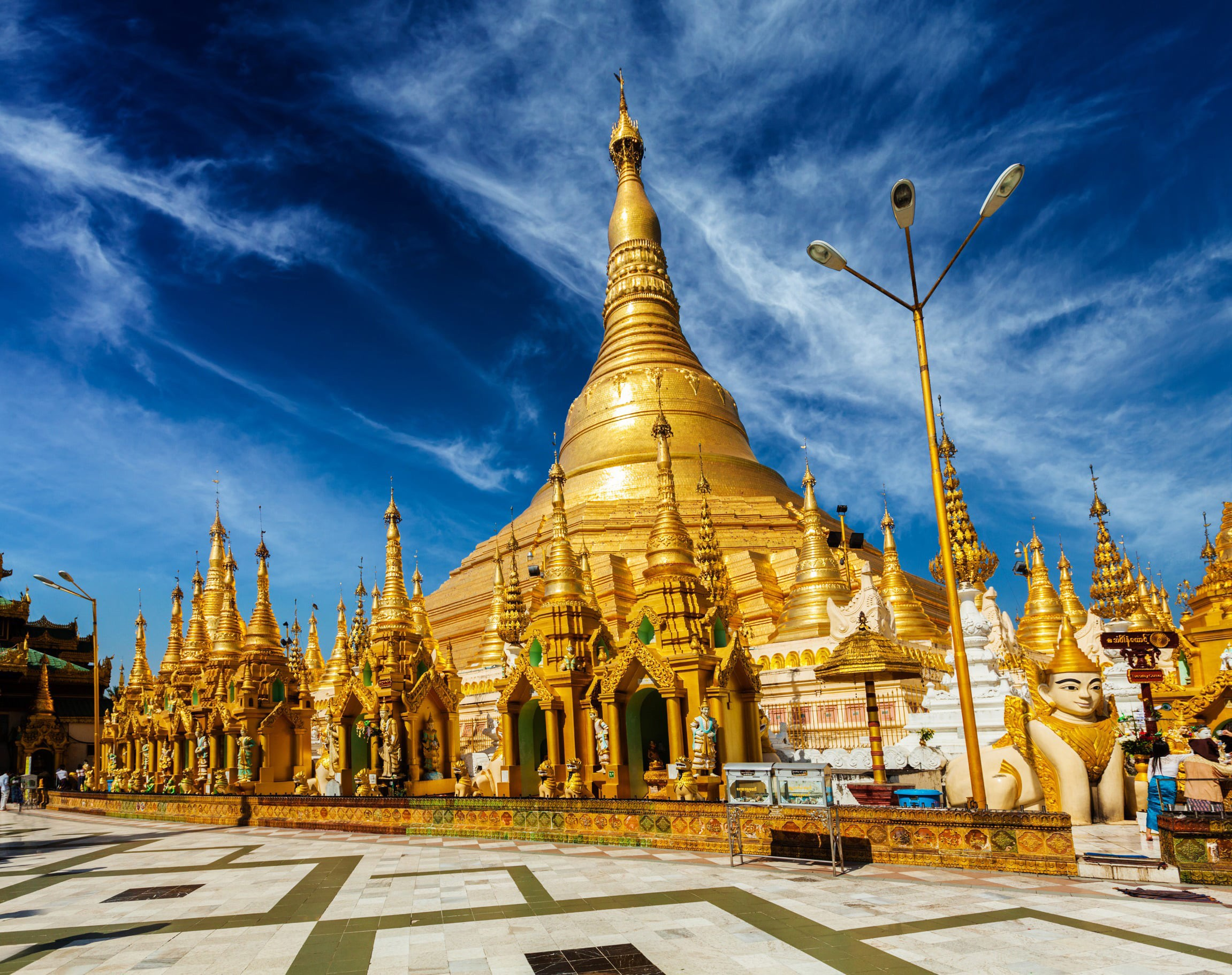 View oblique from below of famous temple in gold and jewels in Myanmar with beautiful blue sky in the background