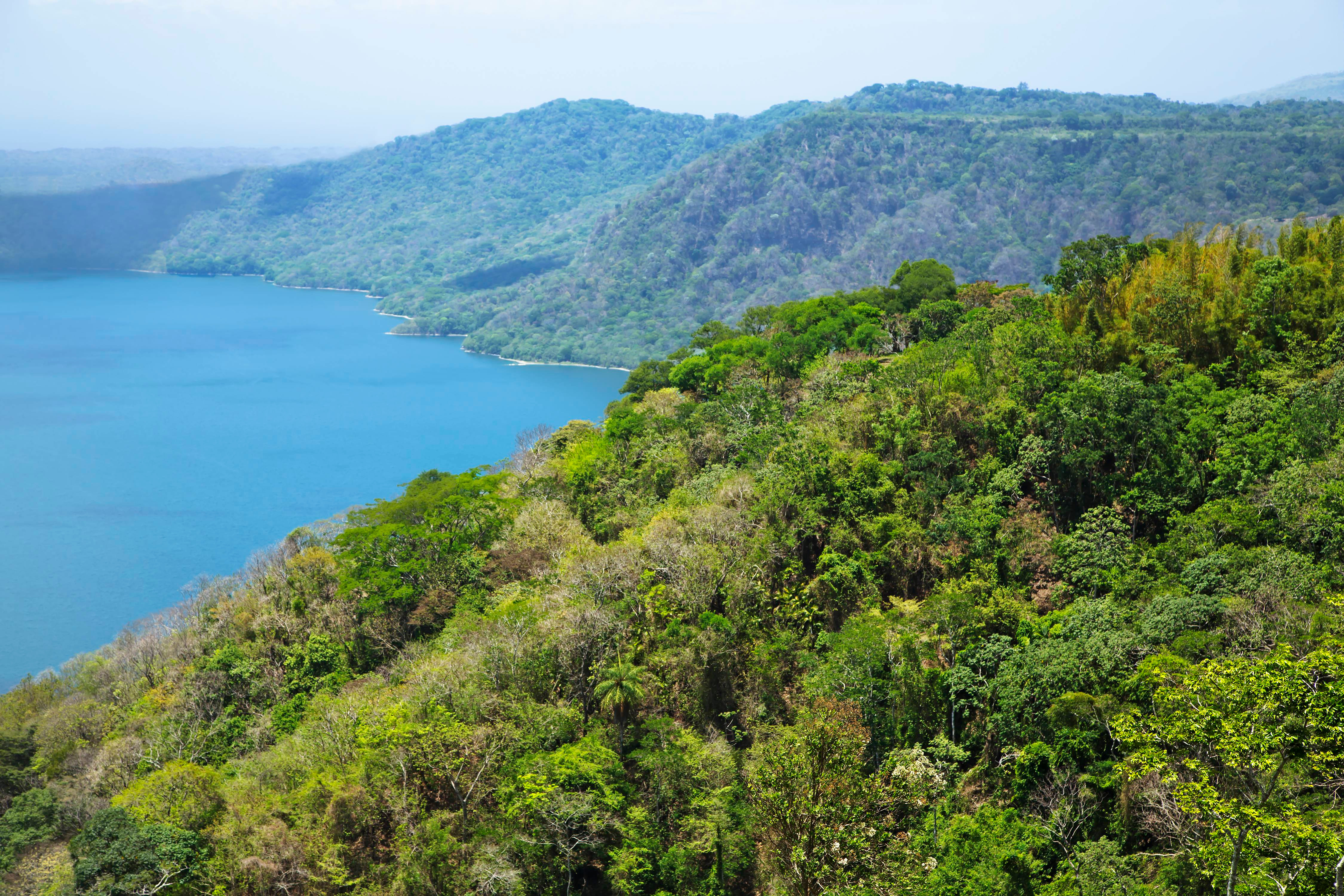 Resa till Nicaragua - Sjö omgiven av frodig grönska och skogklädda berg i tropiskt landskap.