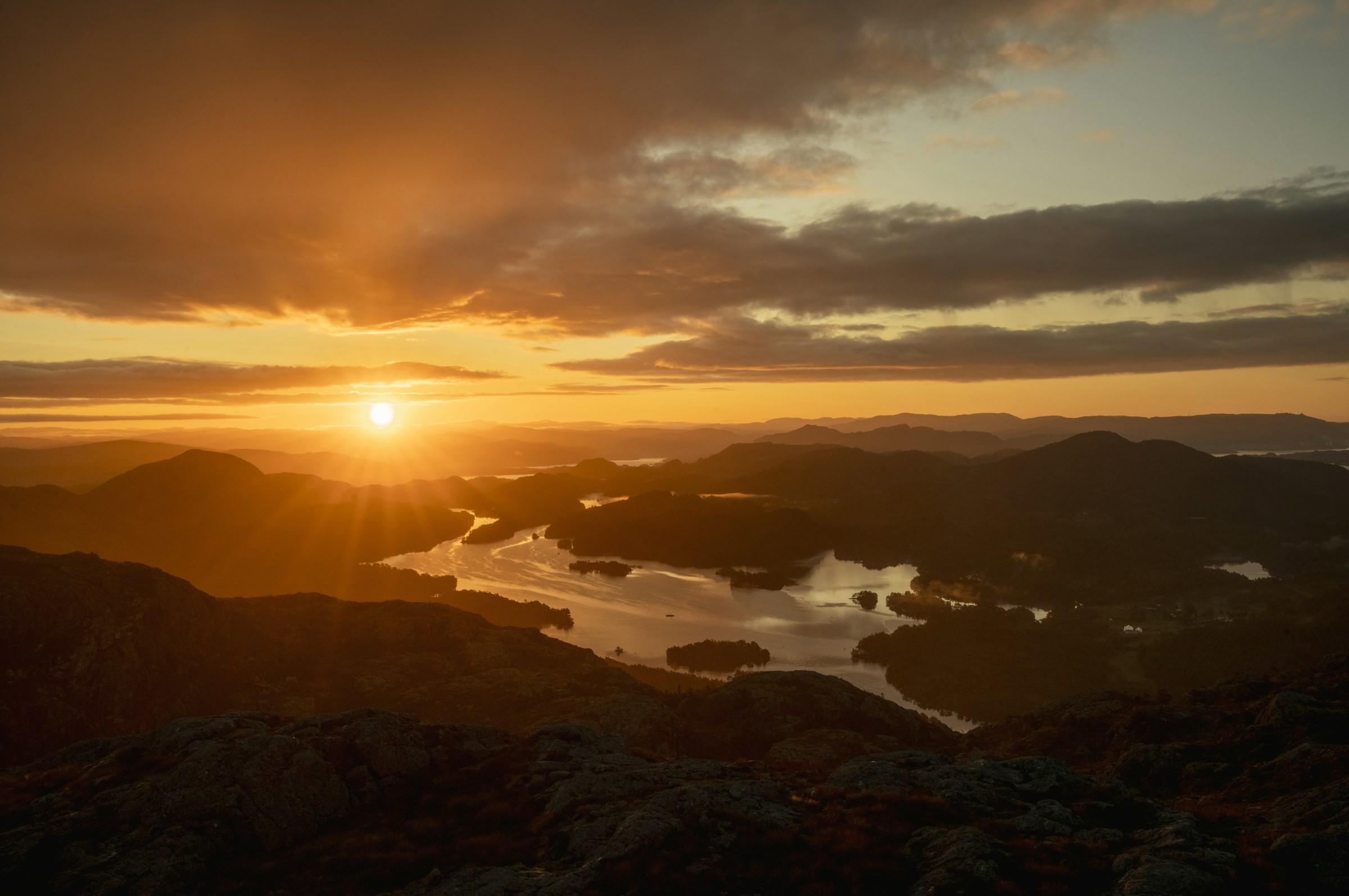 Vacker gul solnedgång över fjordar och en insjö i Bergen, Norge