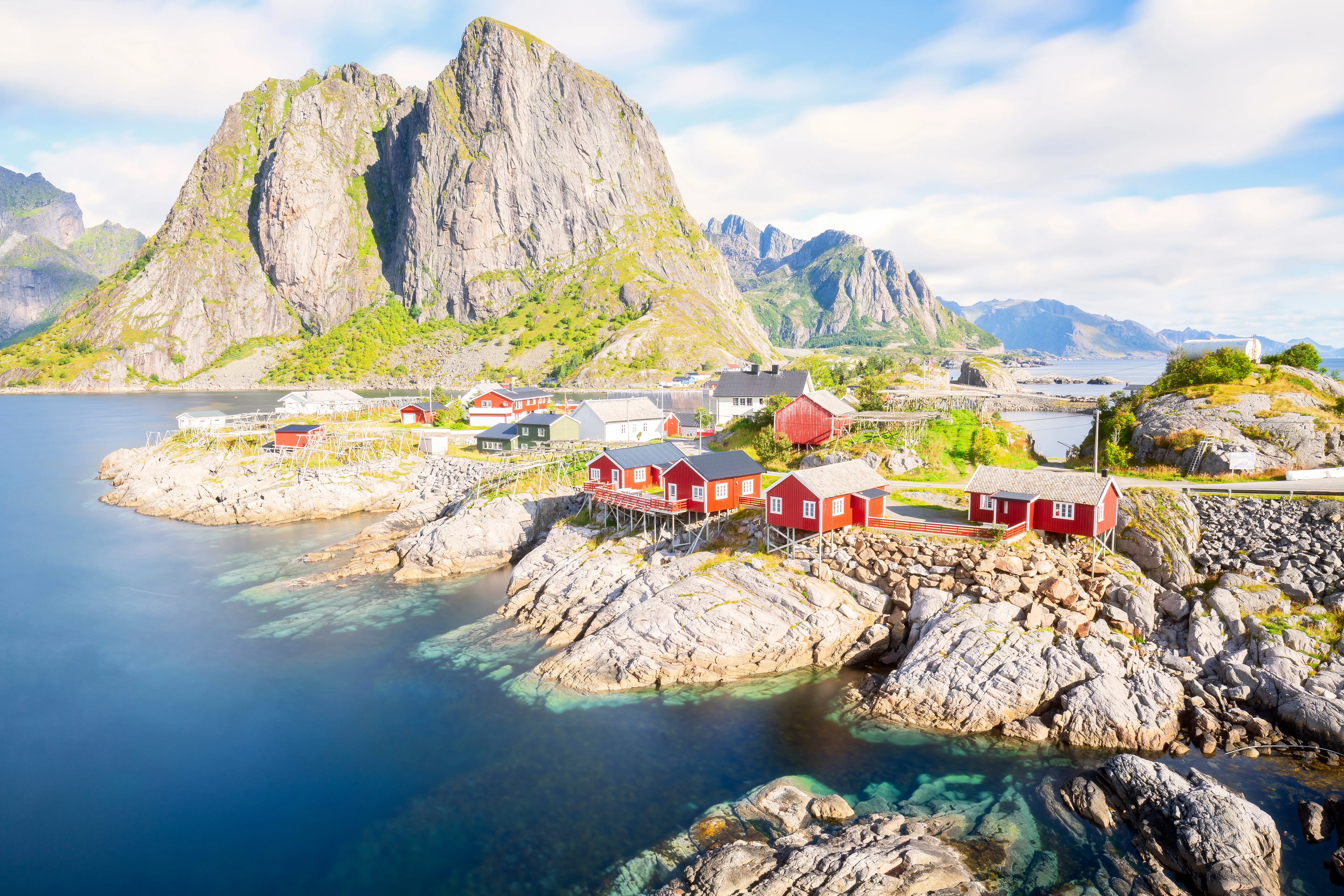 Resa till Lofoten - Röda norska fiskestugor vid foten av karga berg på Lofotenöarna, Norge, perfekt för resor och nordisk natur.