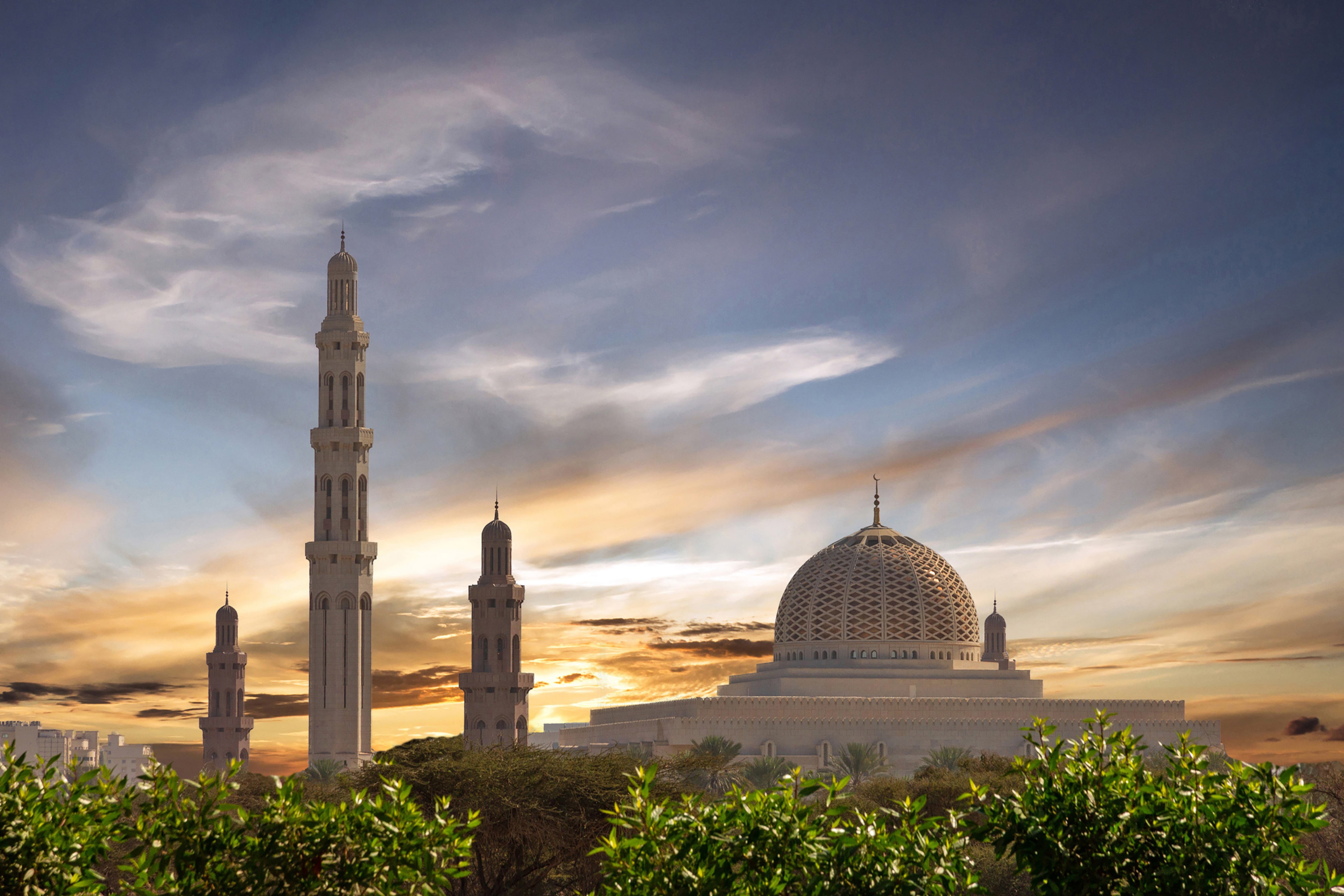 Travel to Muscat - Sunset at a beautiful mosque surrounded by green trees and bushes