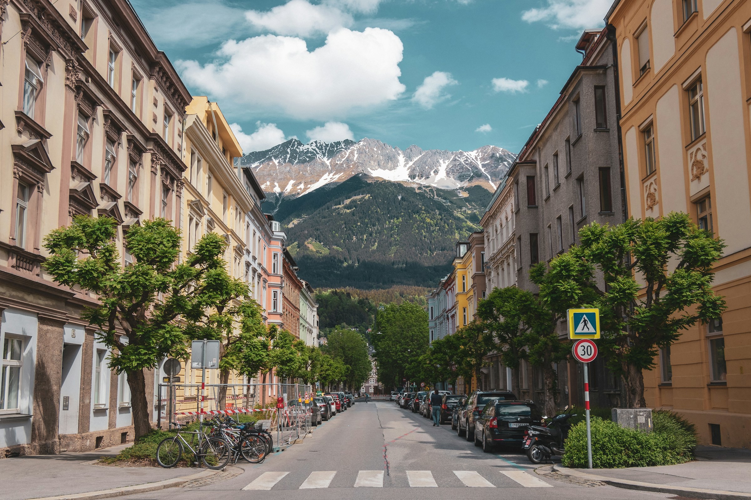 Gata i Innsbruck med snötäckta berg i bakgrunden och klassisk arkitektur.