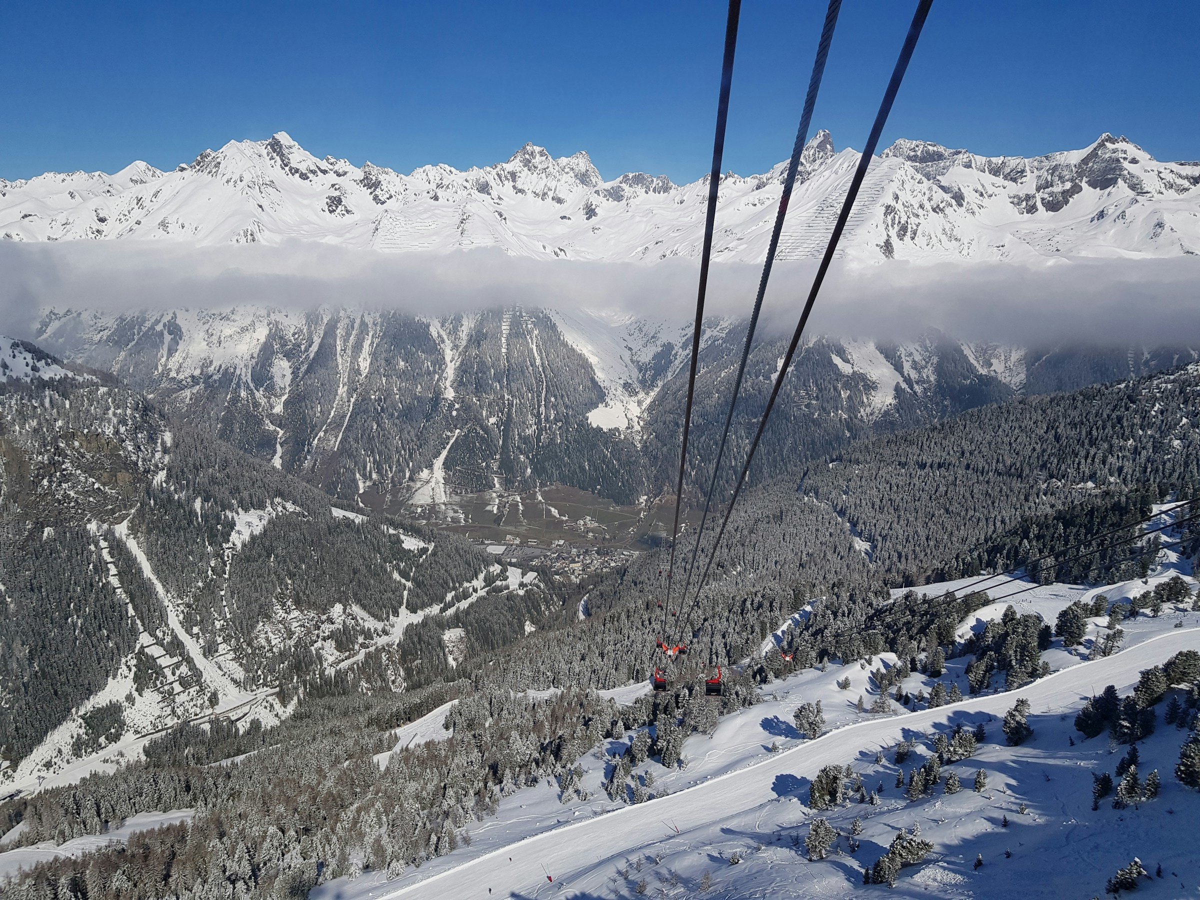 Vy över snöklädda berg och skidlift i Alperna, Ischgl med klarblå himmel