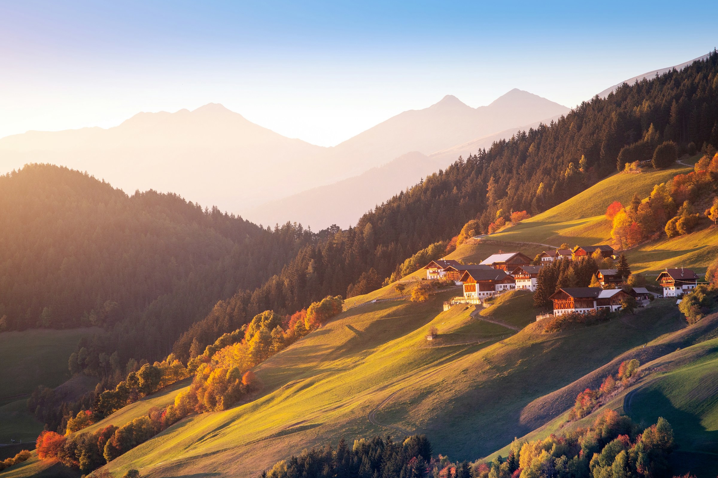 Sunset over green plains among the mountains of Austria with blue sky in the background