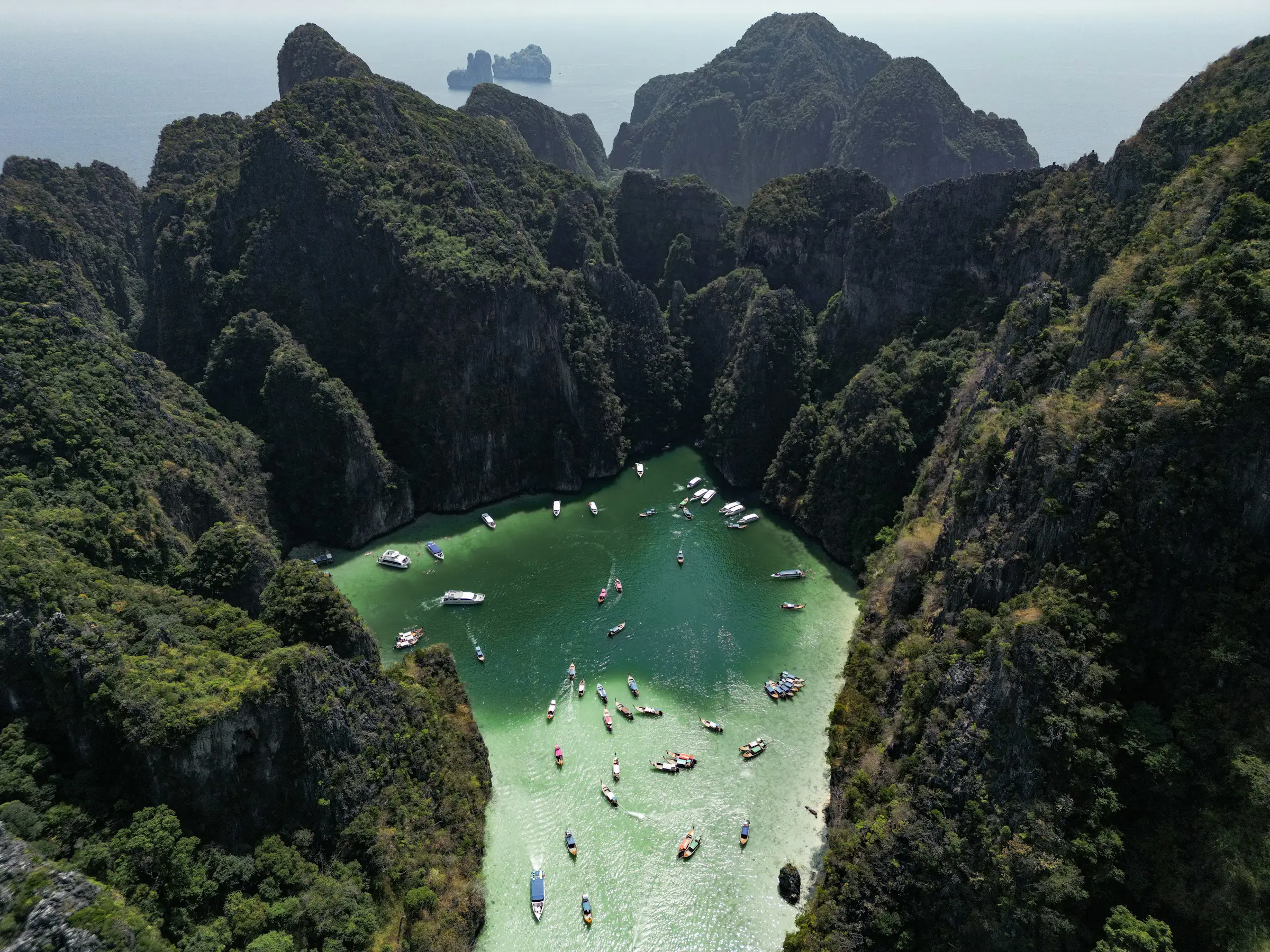 Bird's eye view of Pileh Lagoon at Phi Phi islands in Thailand with blue sea surrounded by verdant mountains